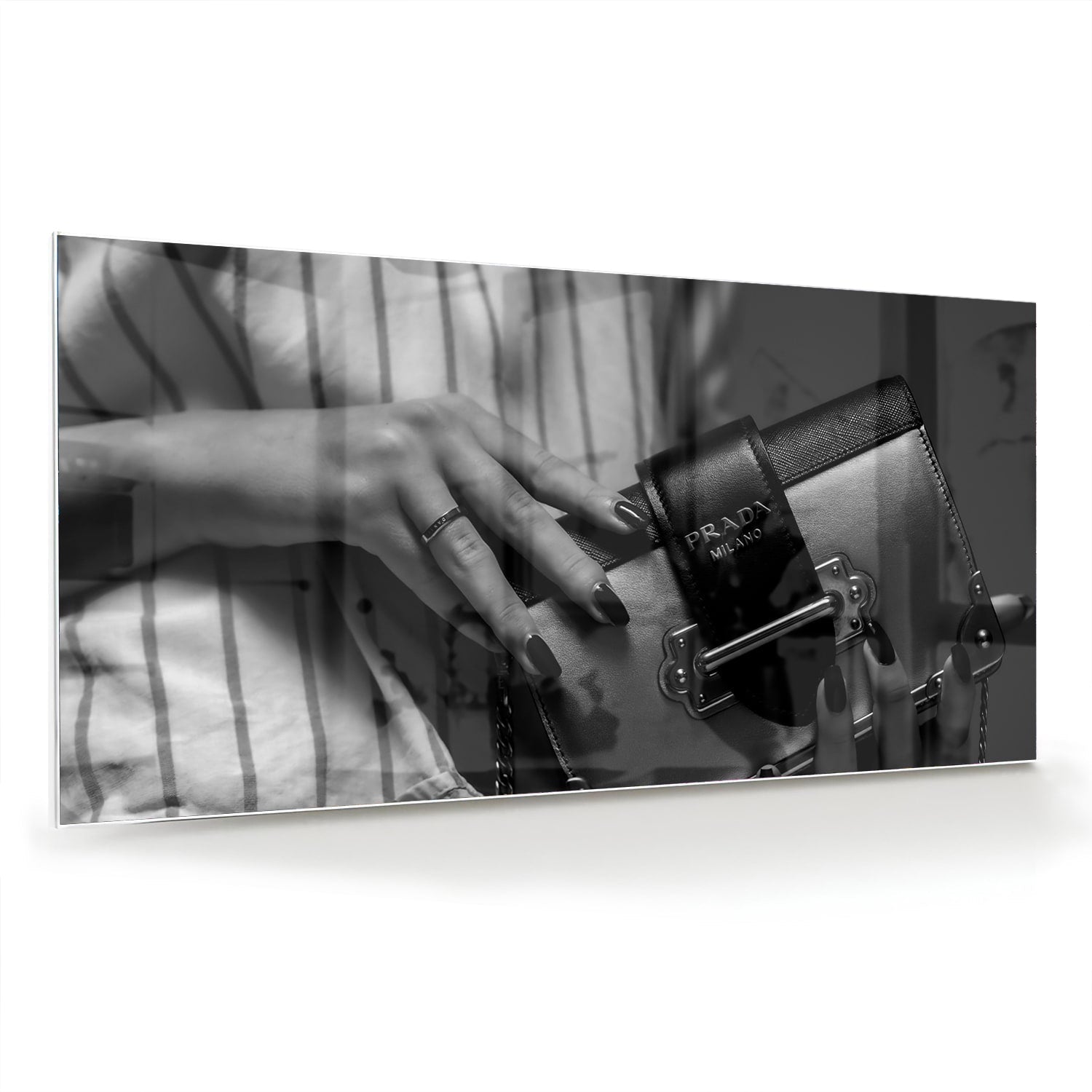 Glazen schilderij met close-up van luxe accessoires op een wand.