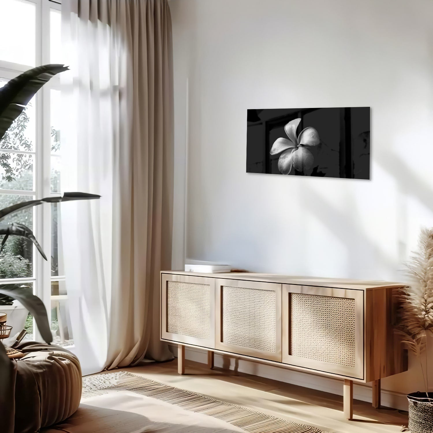 Zwart glazen schilderij met bloemmotief boven een houten kast in een lichte kamer.