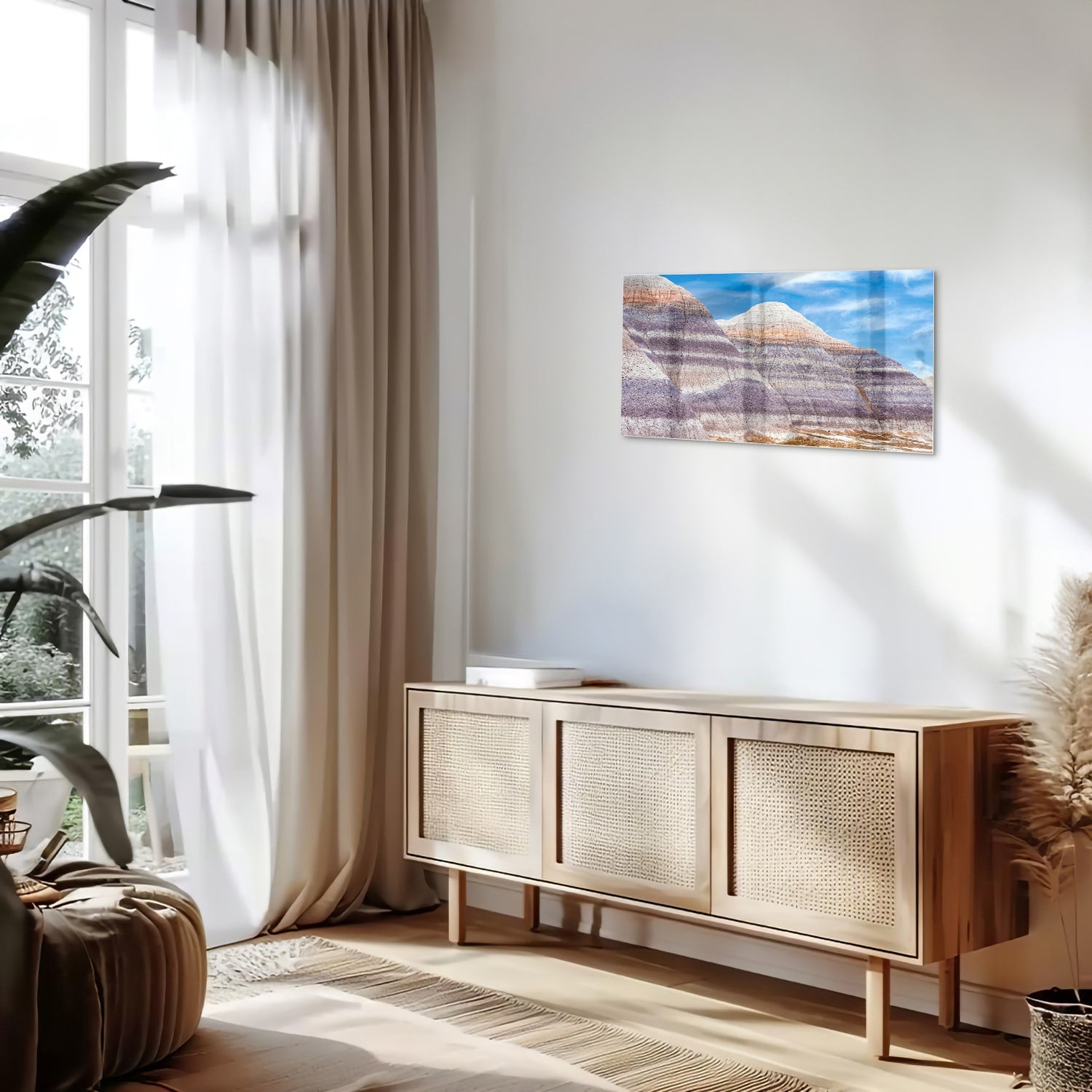 Glazen schilderij van bergen met een blauwe lucht in een moderne woonkamer.