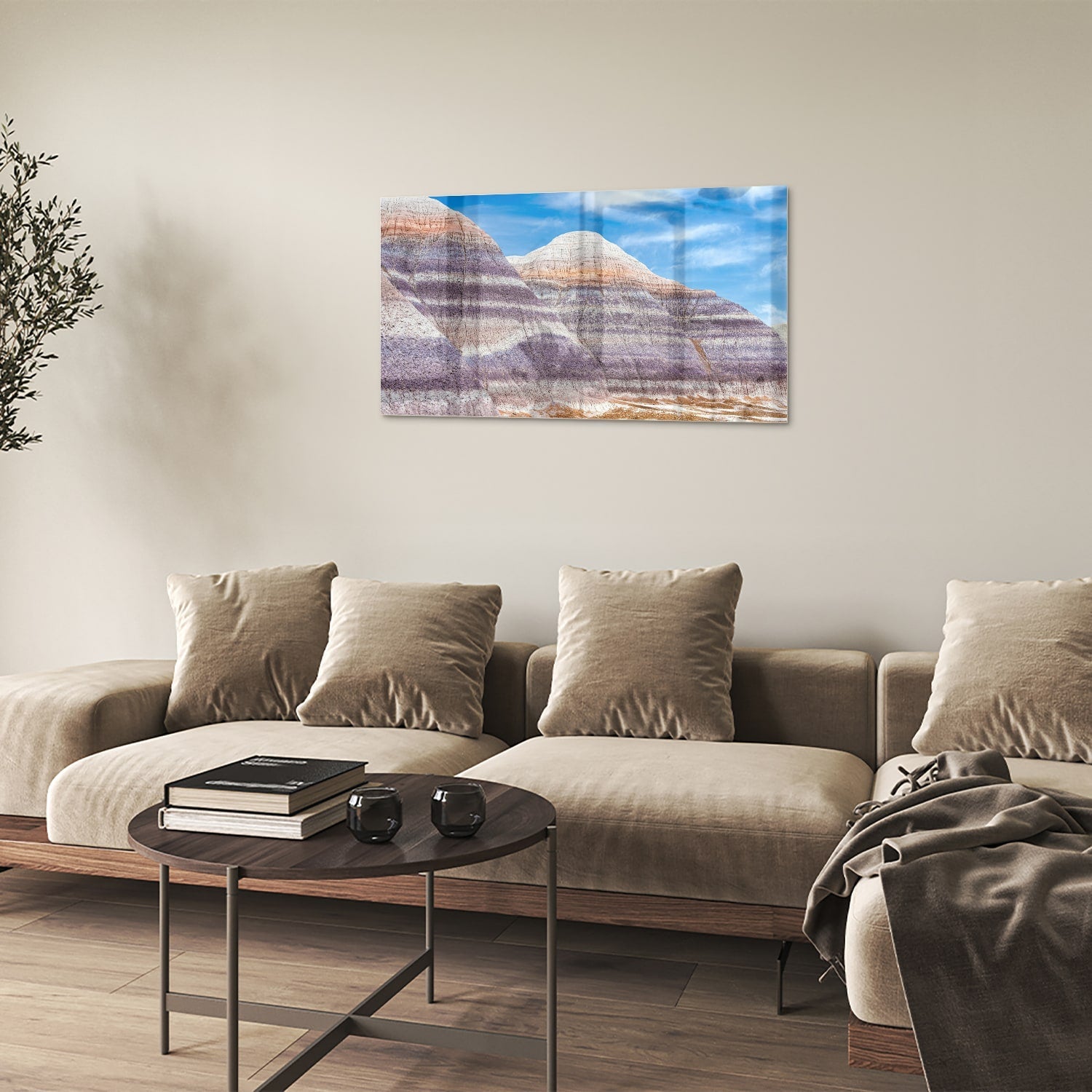 Glazen schilderij van bergen met een blauwe lucht in een moderne woonkamer.