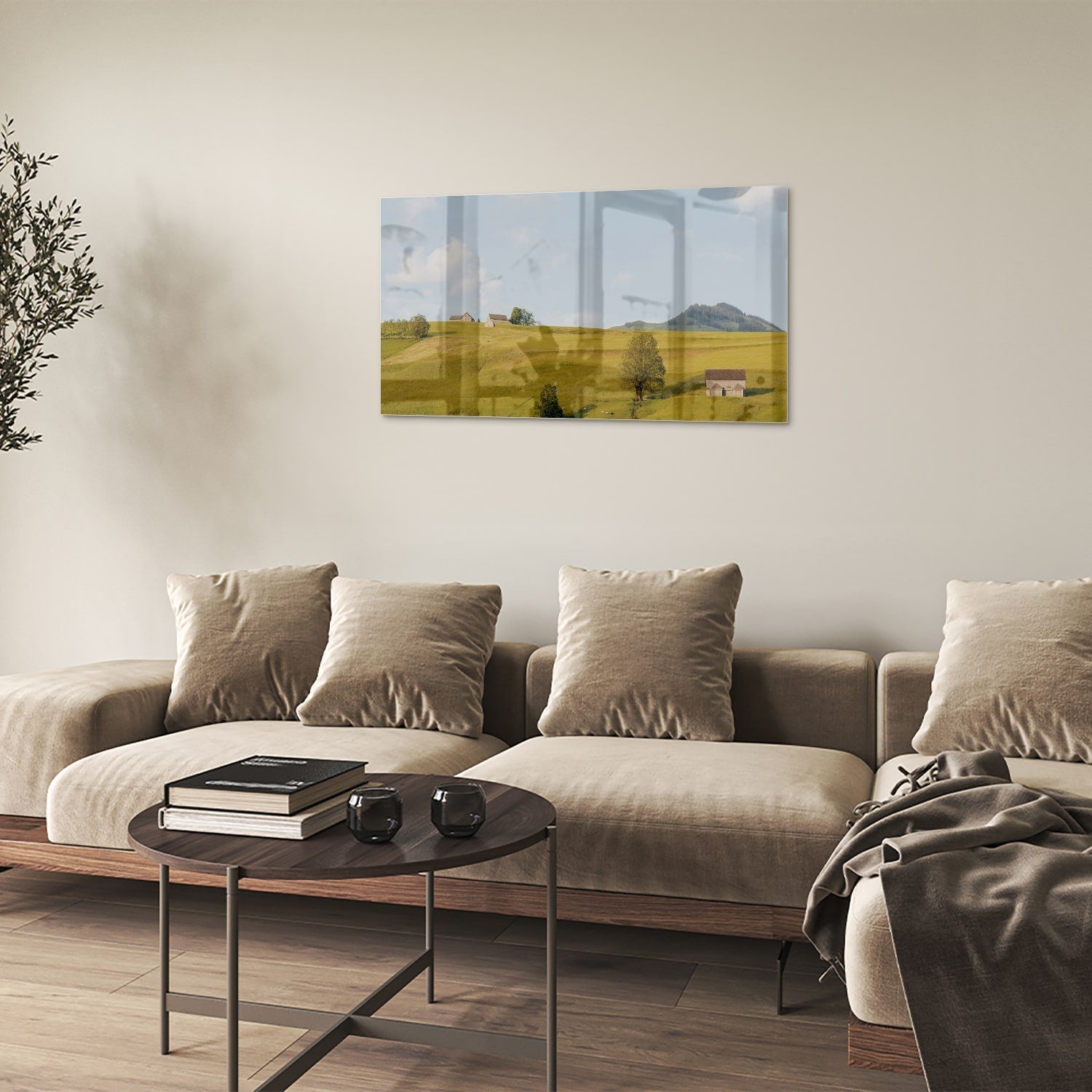 Glazen schilderij met groene heuvels en boerderijen op een witte muur.