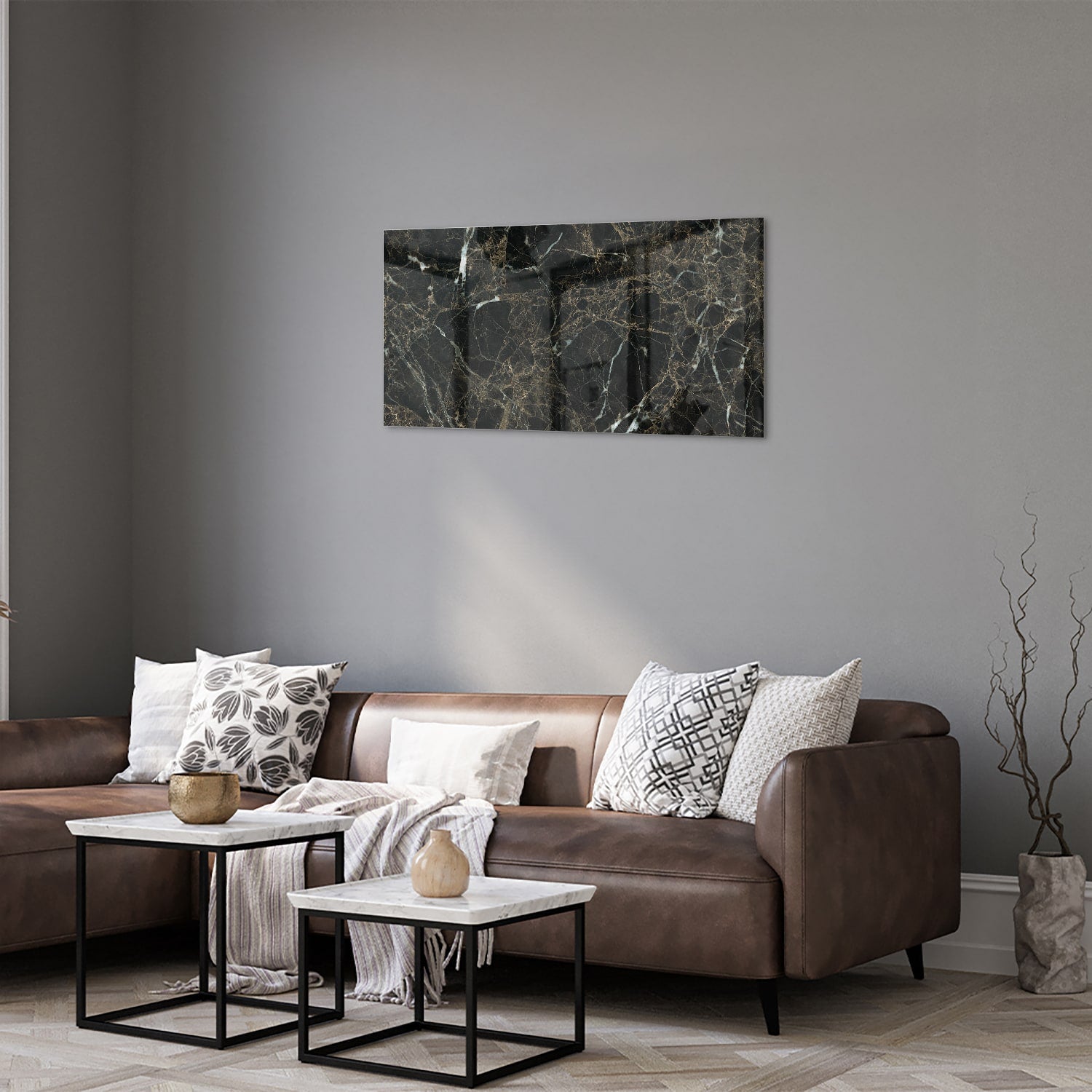 Glazen schilderij van zwart marmer met gouden aderen, hangt boven een moderne meubelstuk.