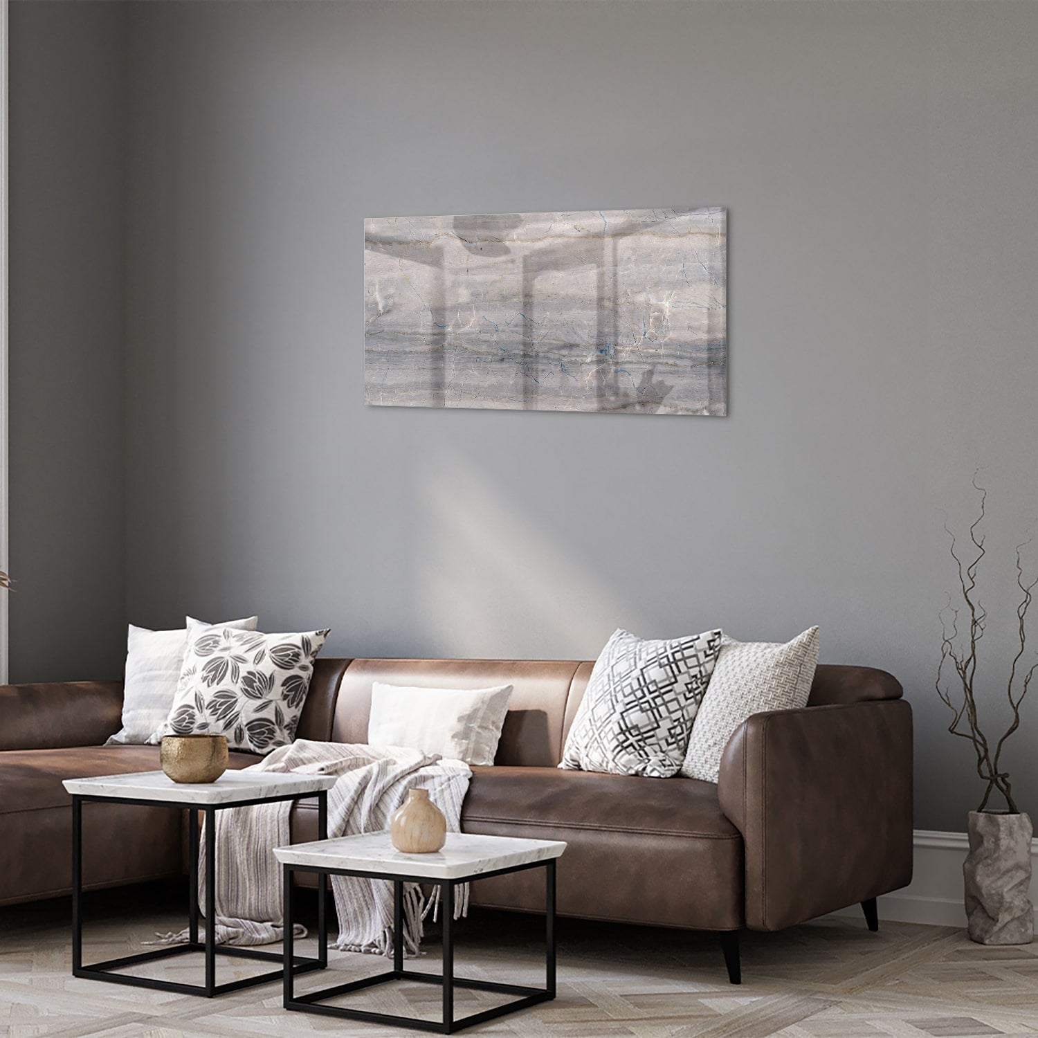 Glazen schilderij in aardetinten hangt aan de muur in een moderne woonkamer.