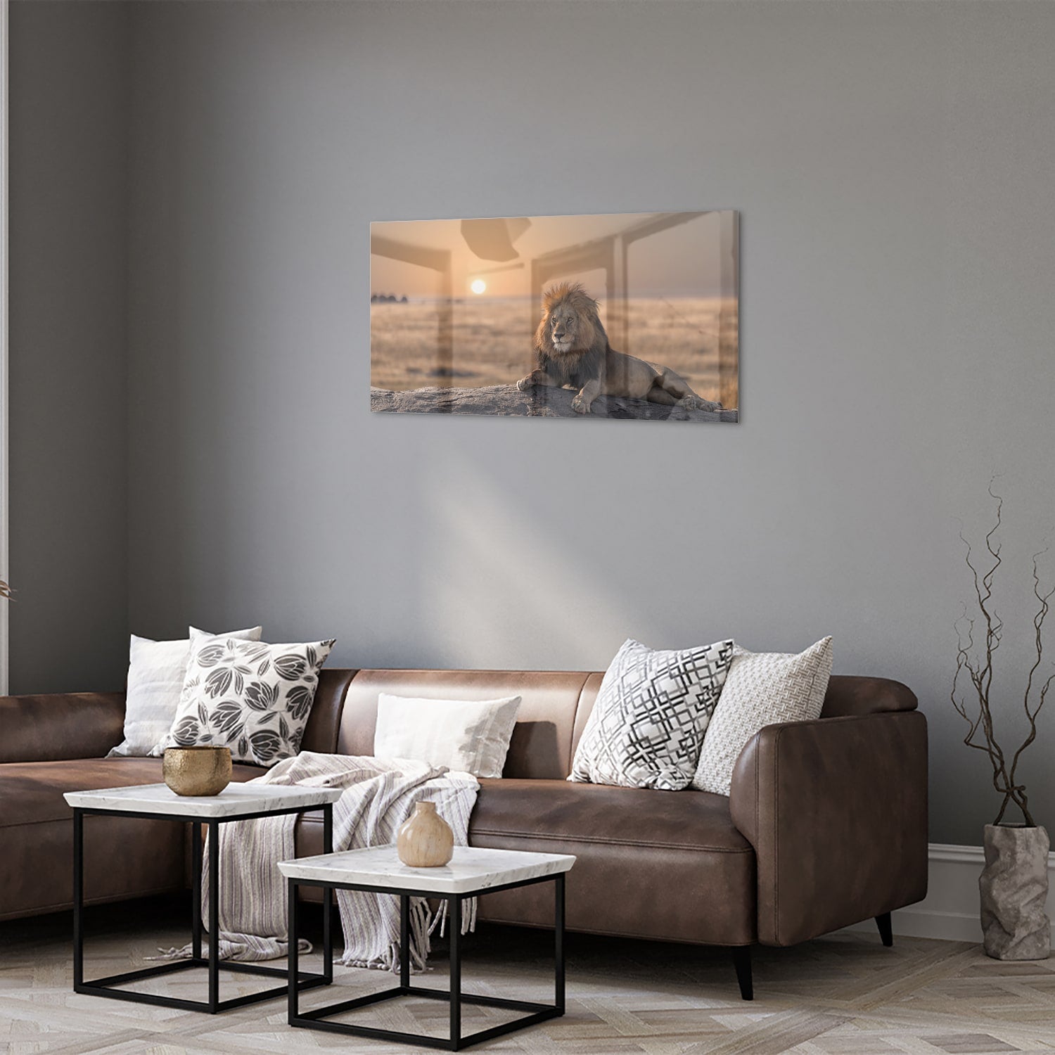 Glazen schilderij van een leeuw die op een rots ligt met zonsondergang op de achtergrond.