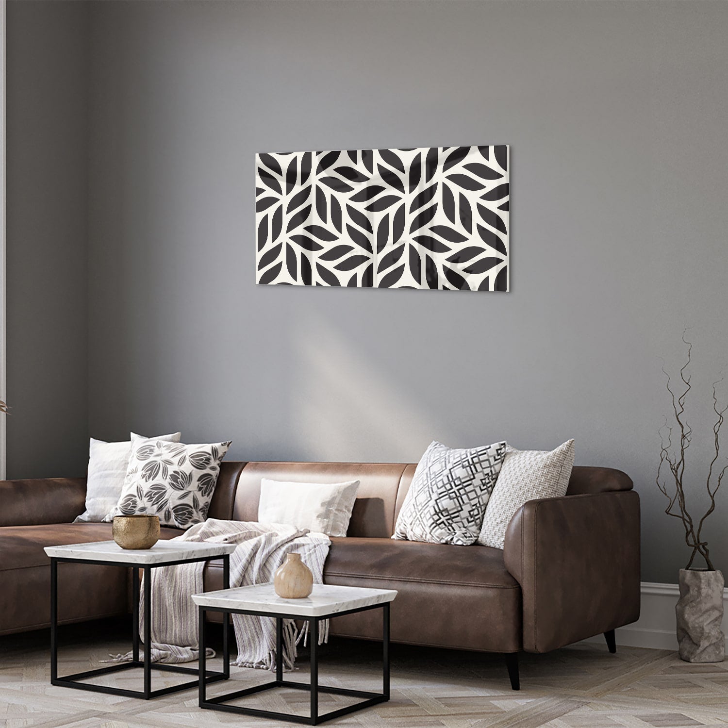 Zwart-wit glazen schilderij met bladerenpatroon aan de muur in een moderne woonkamer.