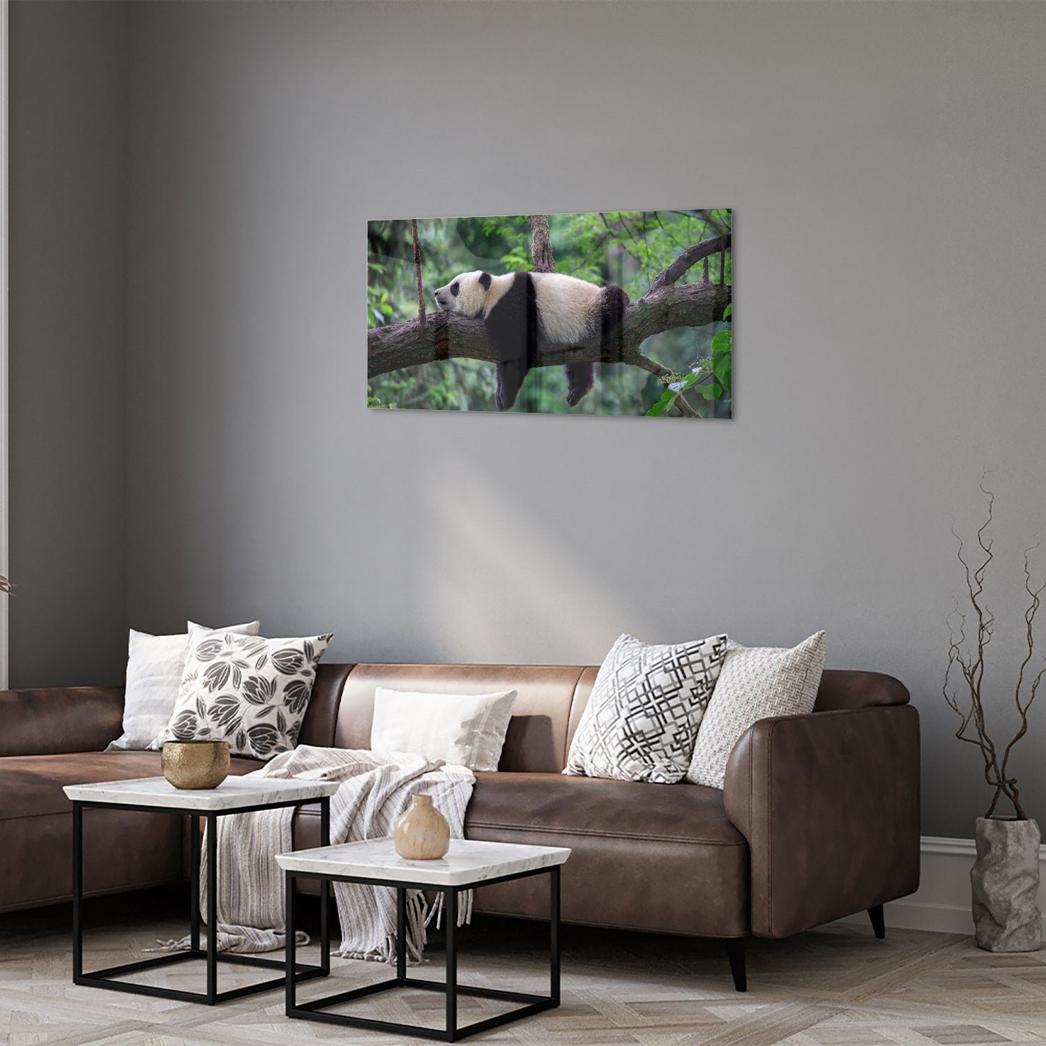 Glazen schilderij van een panda die ontspannen op een tak ligt.