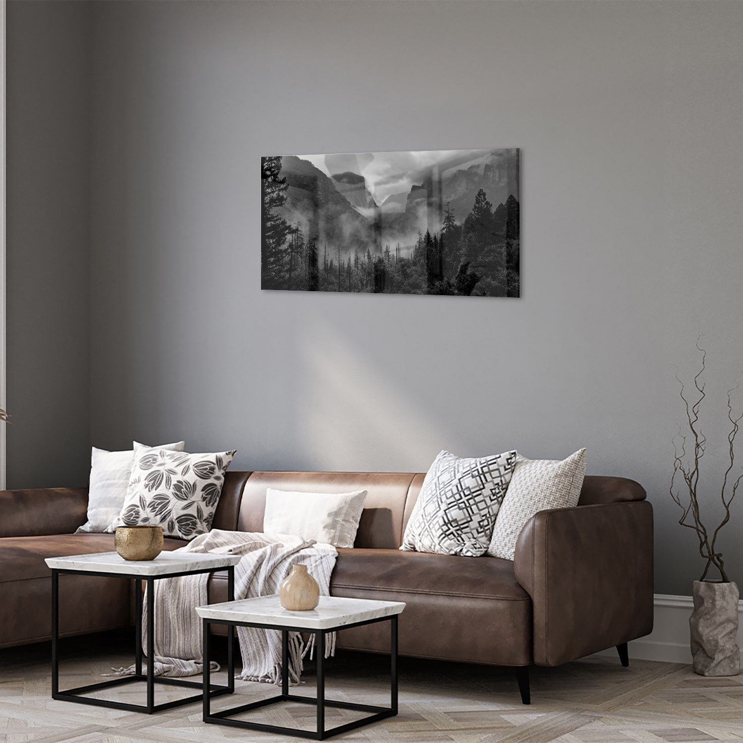 Zwart-wit glazen schilderij van een sereen berglandschap aan de muur.