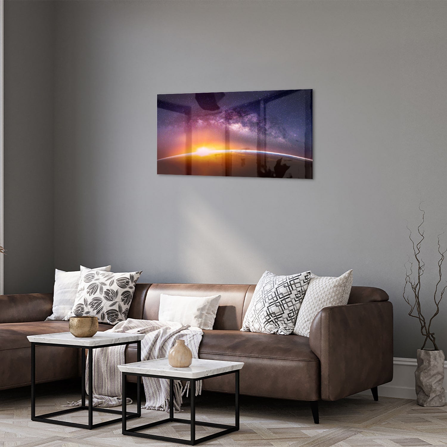 Glazen schilderij van een sterrenhemel met zonsondergang, hangt aan de muur in een stijlvolle woonkamer.