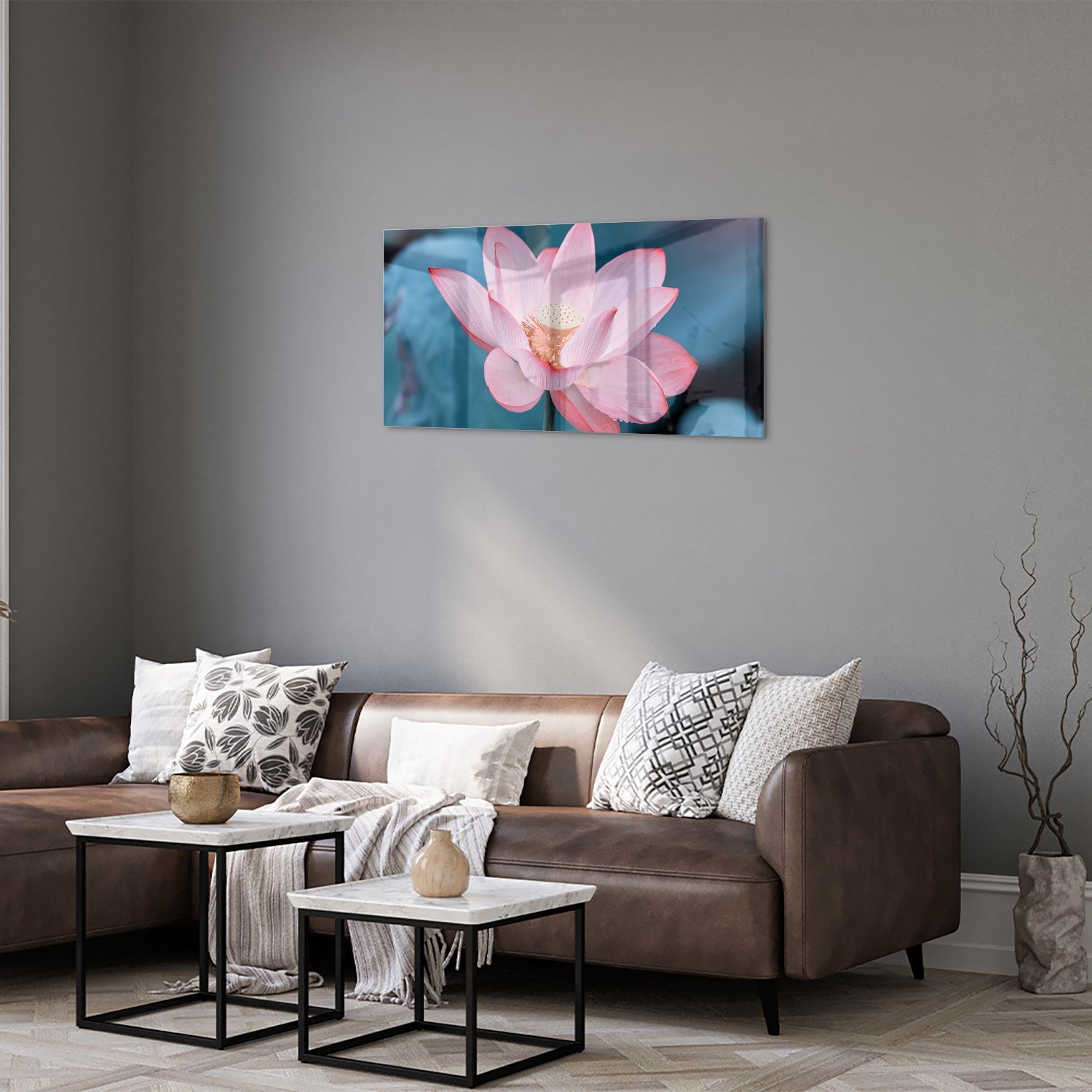 Glazen schilderij van een roze lotus boven een houten meubelstuk in een gezellige woonkamer.