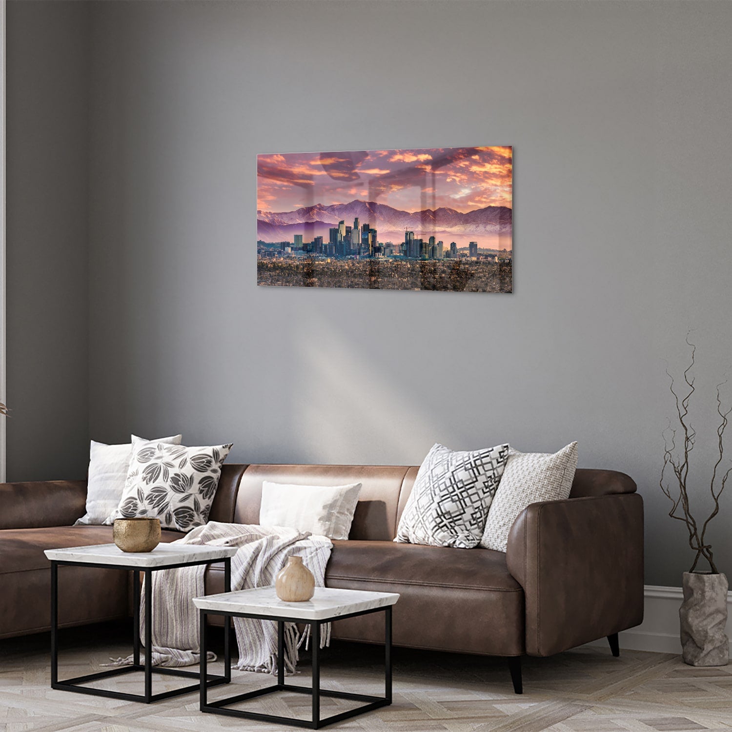 Glazen schilderij van een stadspanorama bij zonsondergang met bergen op de achtergrond.