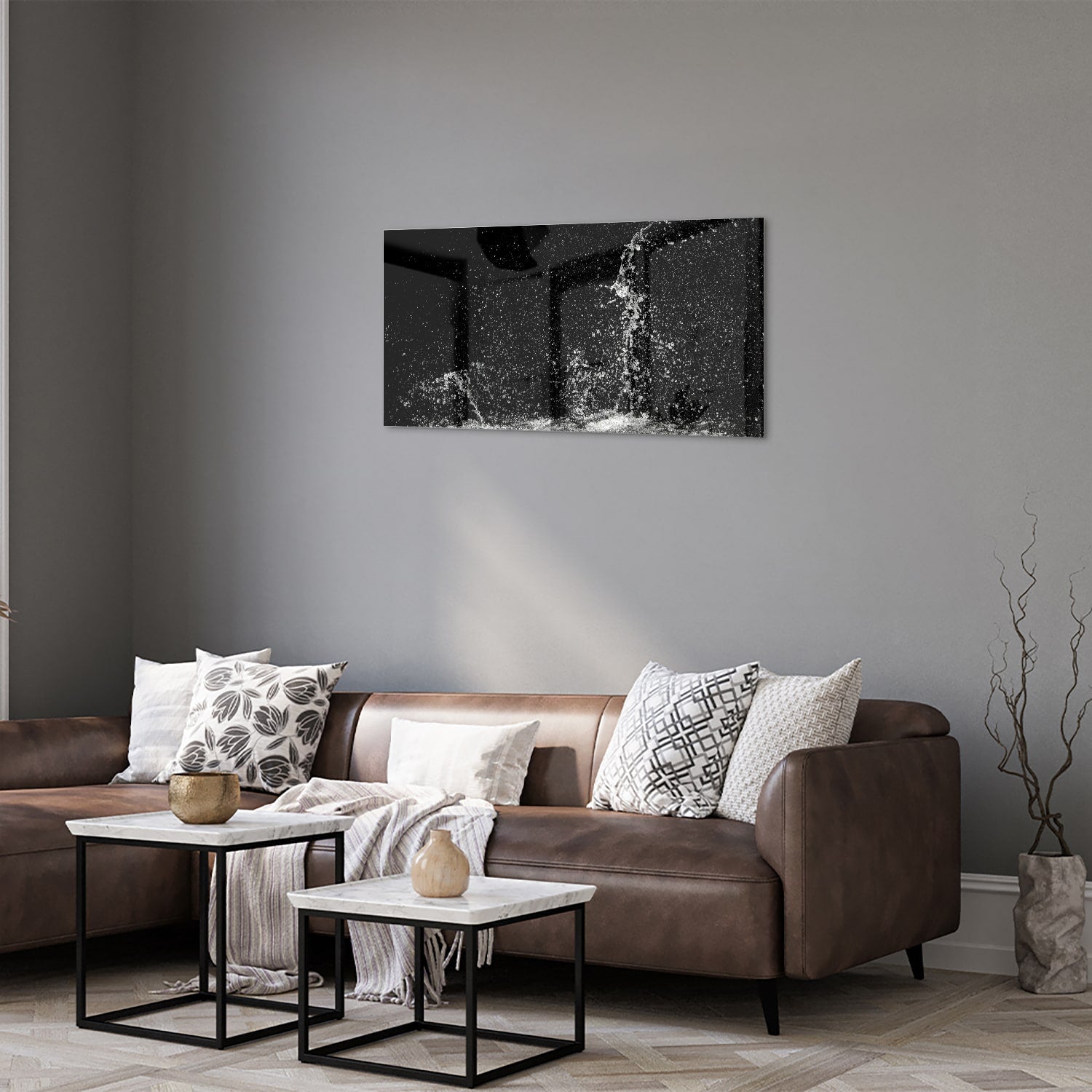 Zwart-wit glazen schilderij met een dynamisch spatwatereffect aan de muur.