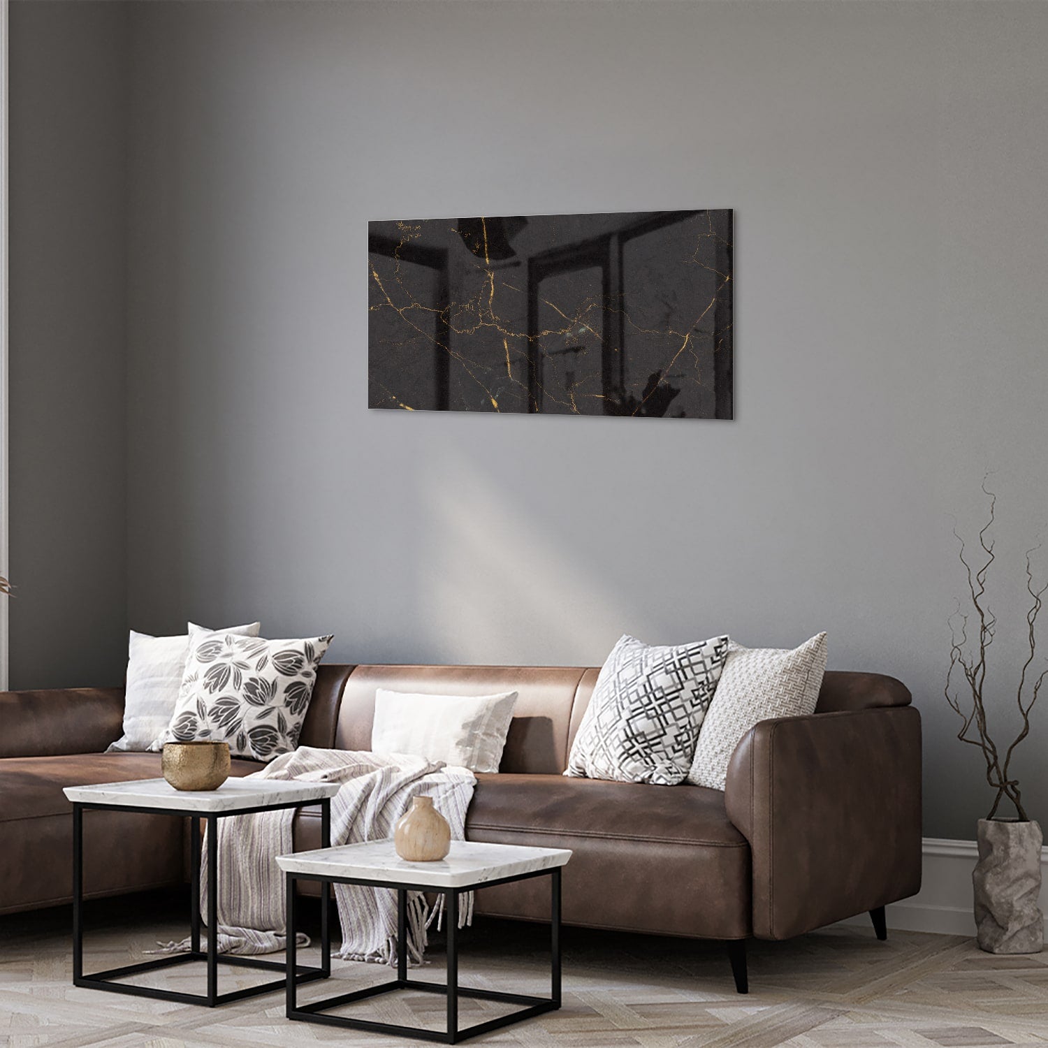 Zwart glazen schilderij met gouden lijnen aan de muur in een moderne woonkamer.