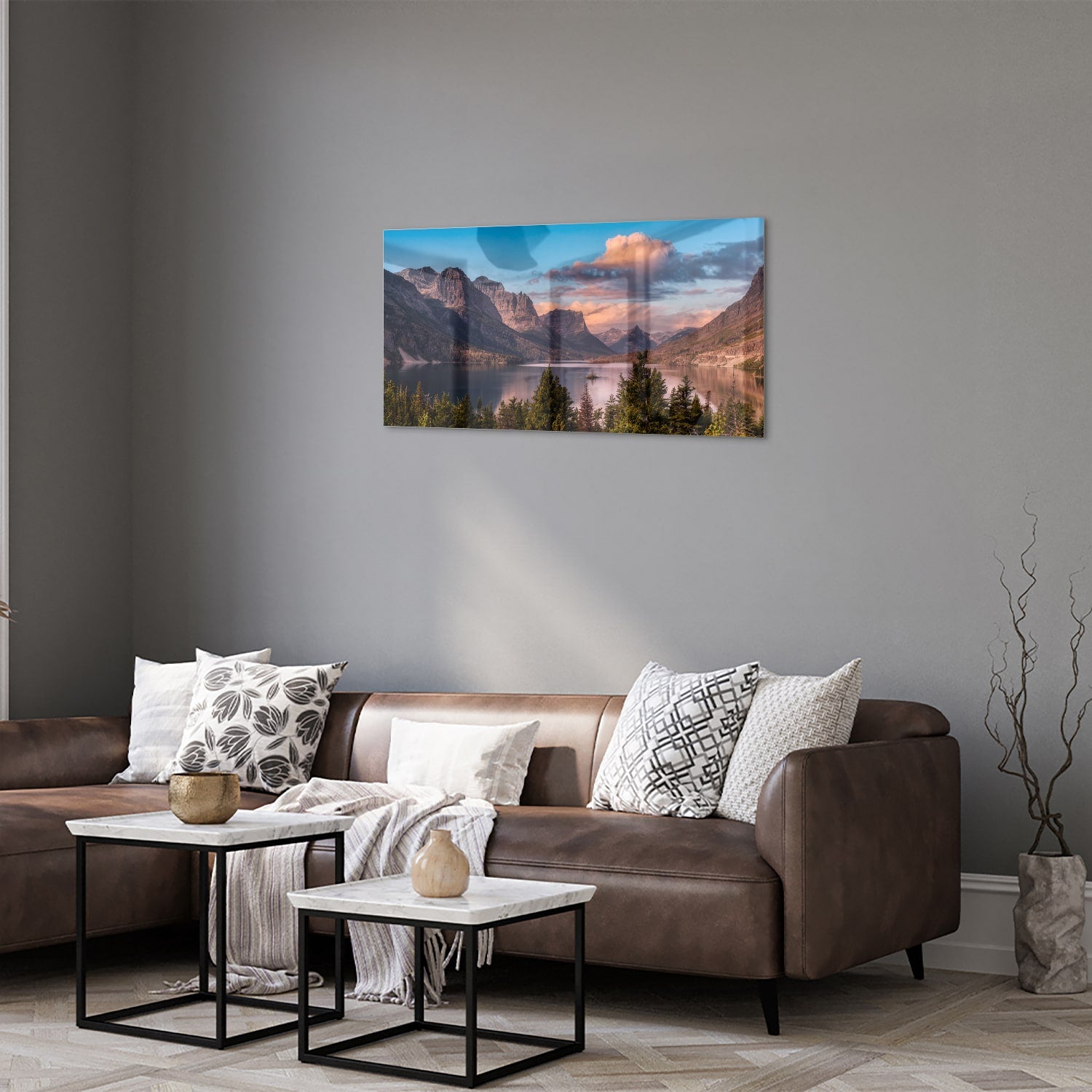 Glazen schilderij van bergen bij zonsopgang in een lichte woonkamer.