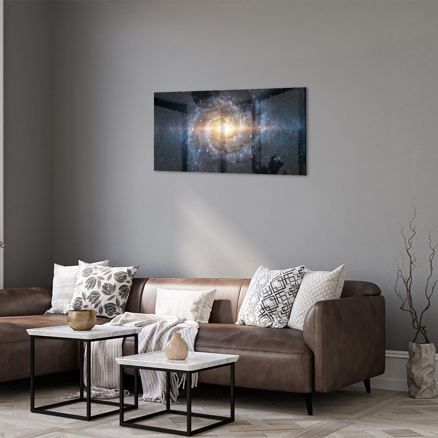 Glazen schilderij van een sterrenstelsel aan de muur in een lichte woonkamer.