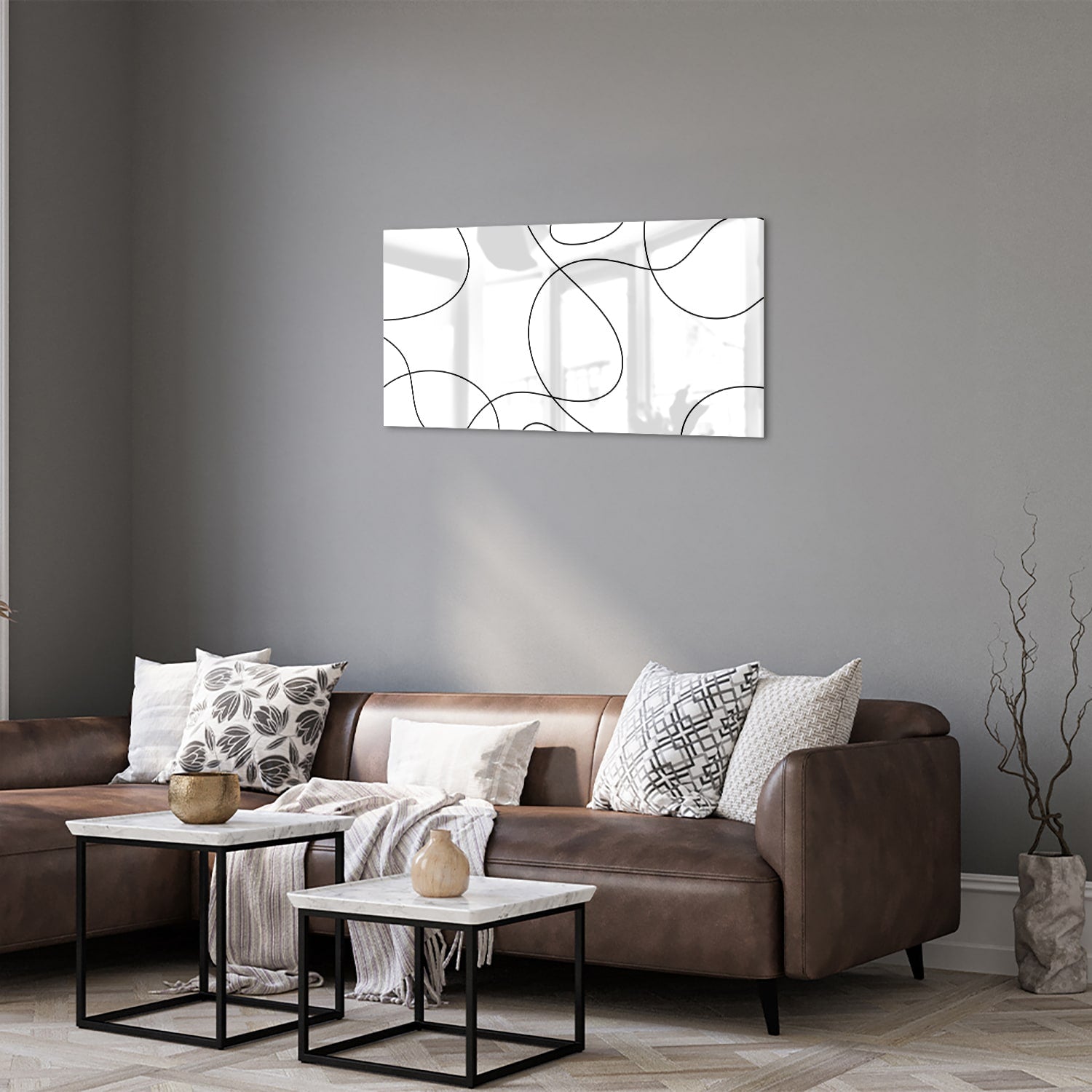 Glazen schilderij met elegante zwarte lijnen in een moderne woonkamer.