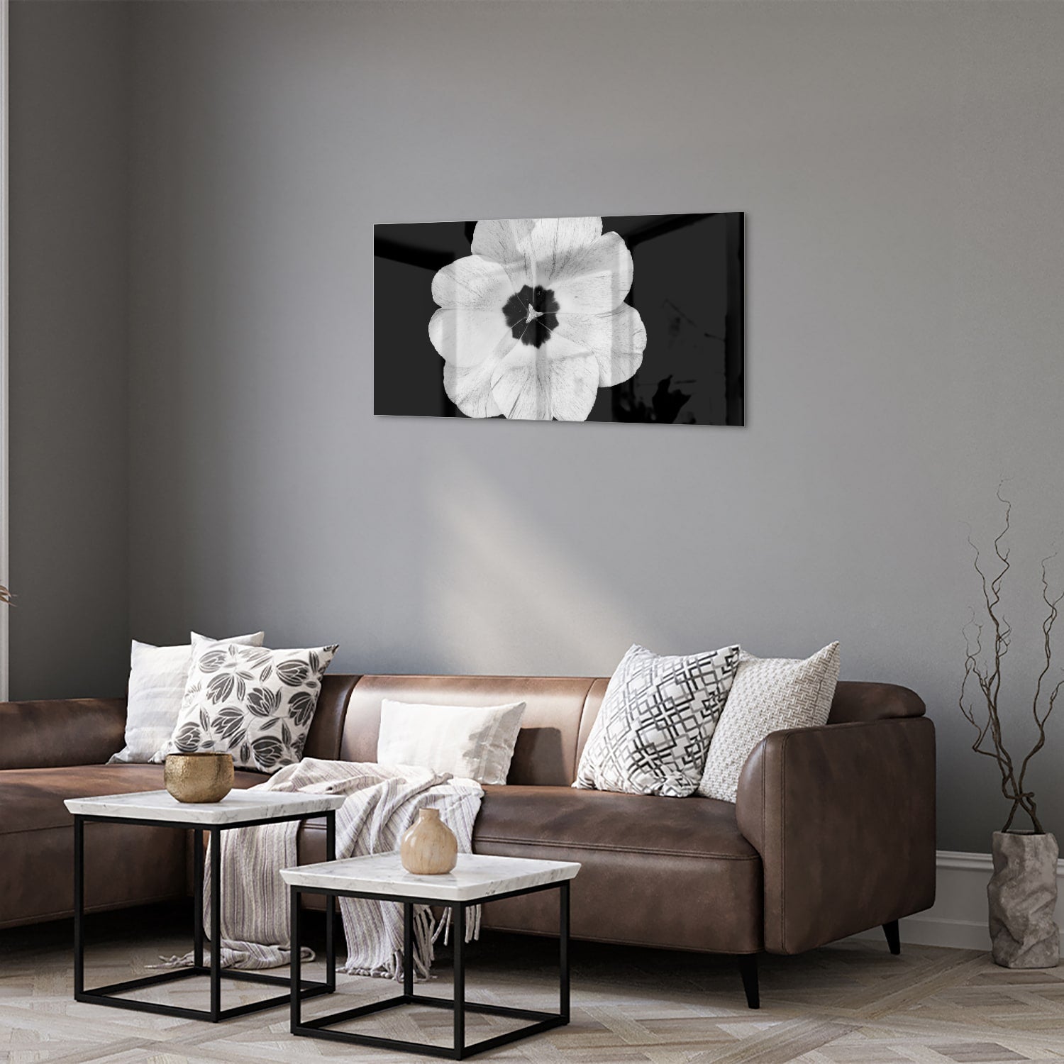 Een glazen schilderij met een witte bloem op een zwarte achtergrond, hangend aan de muur.