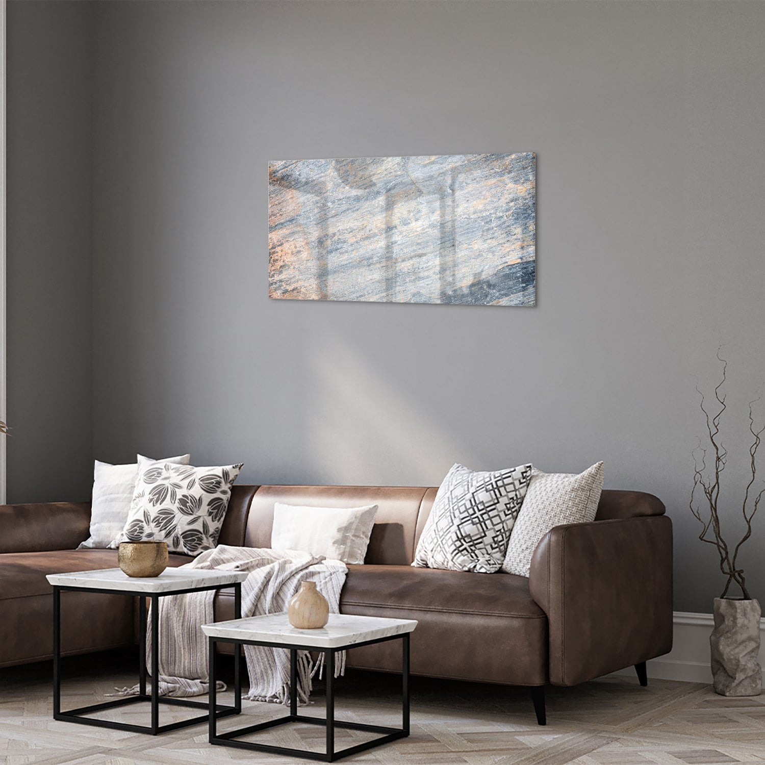 Abstract glazen schilderij met blauwe en oranje tinten aan de muur in een moderne woonkamer.