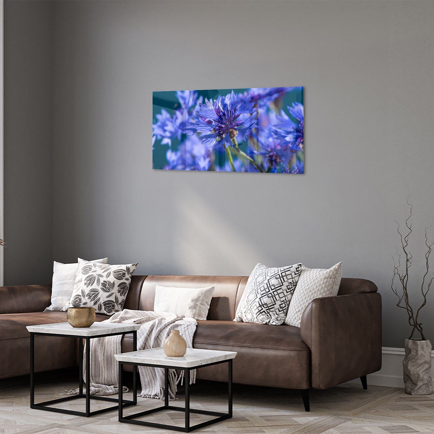 Een glazen schilderij met paarse bloemen op een witte muur, in een sfeervolle woonkamer.
