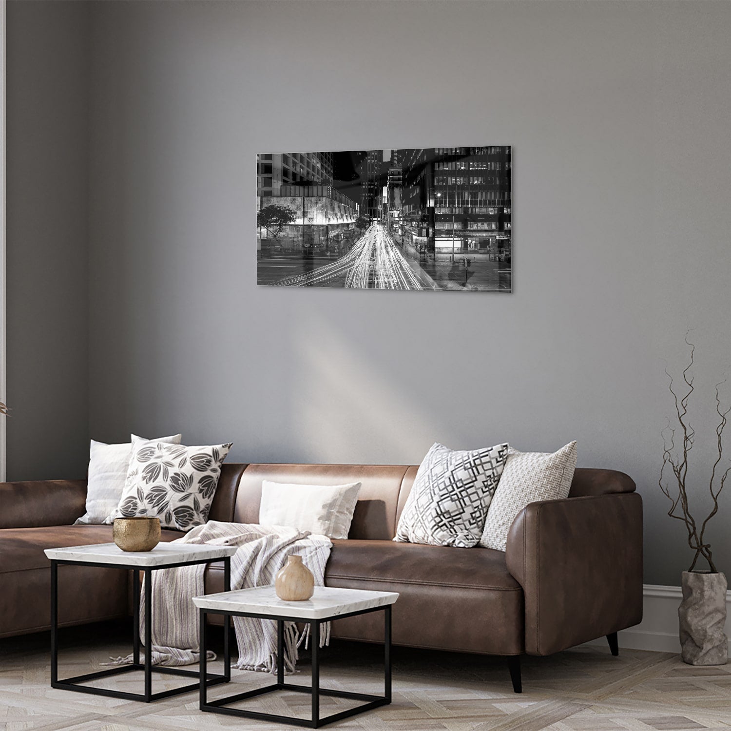 Glazen schilderij met stadslichten in zwart-wit boven een moderne meubelset.