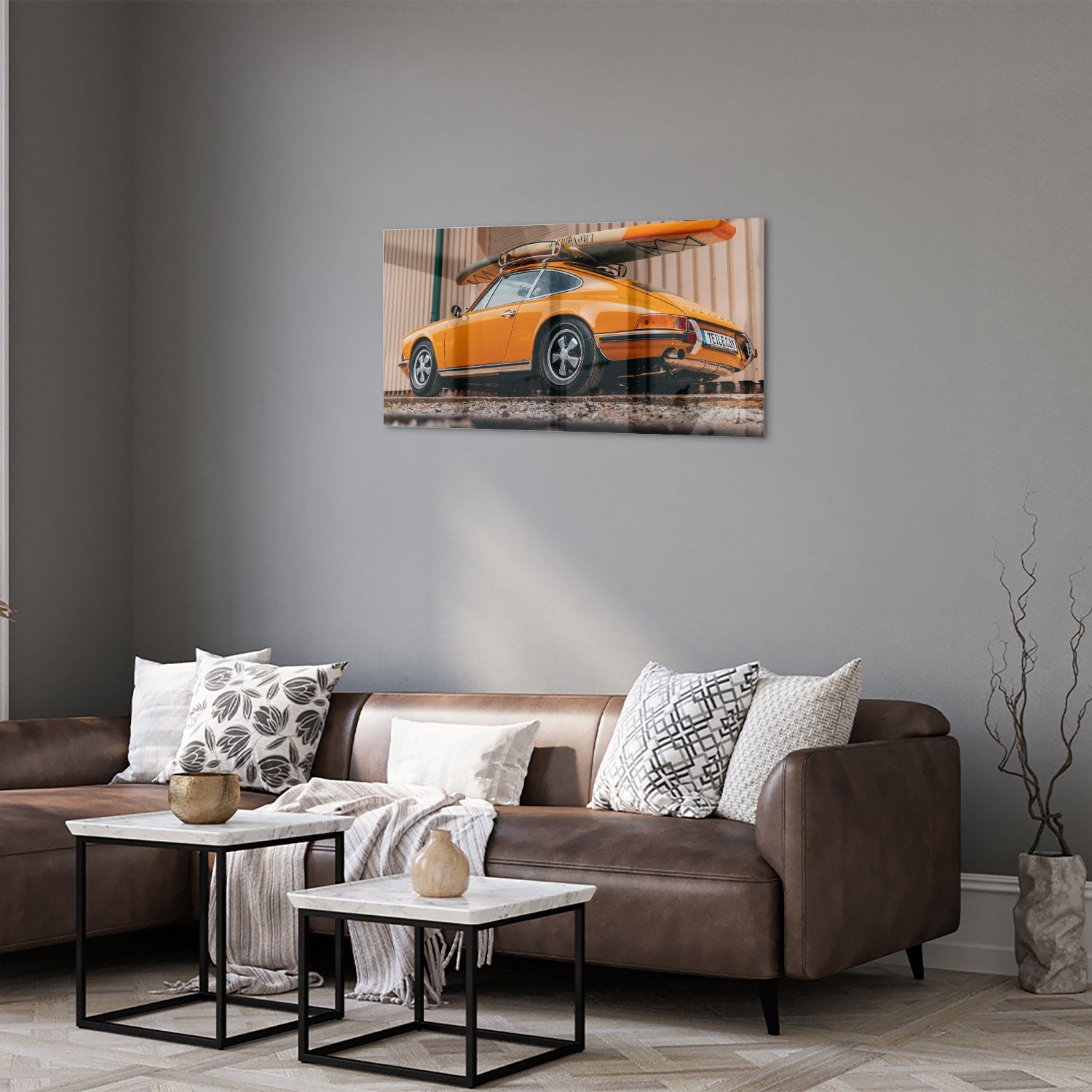 Een glazen schilderij van een oranje auto met een surfbord op het dak, gepresenteerd in een moderne woonkamer.