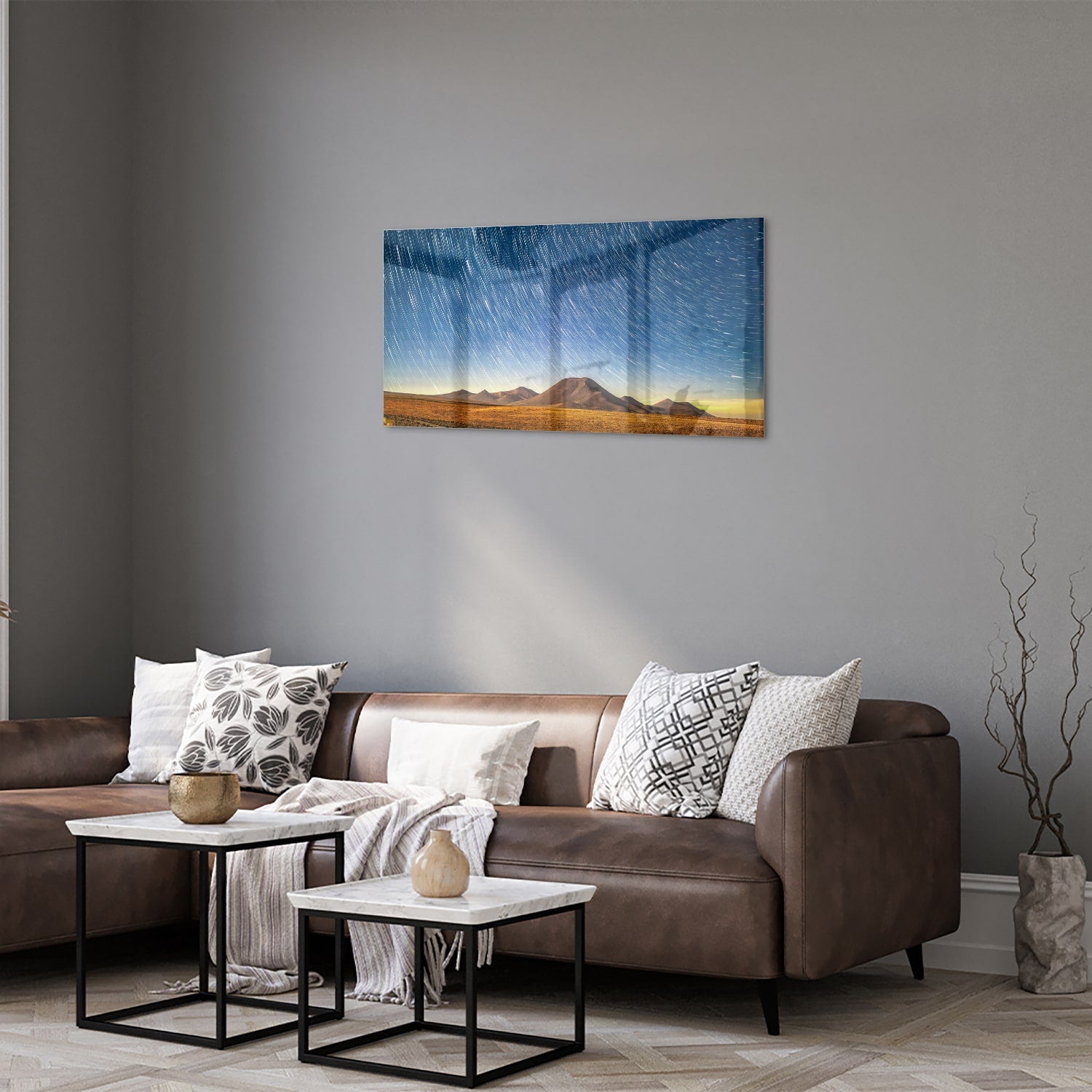 Glazen schilderij met sterrenhemel boven bergen, hangend aan de muur.