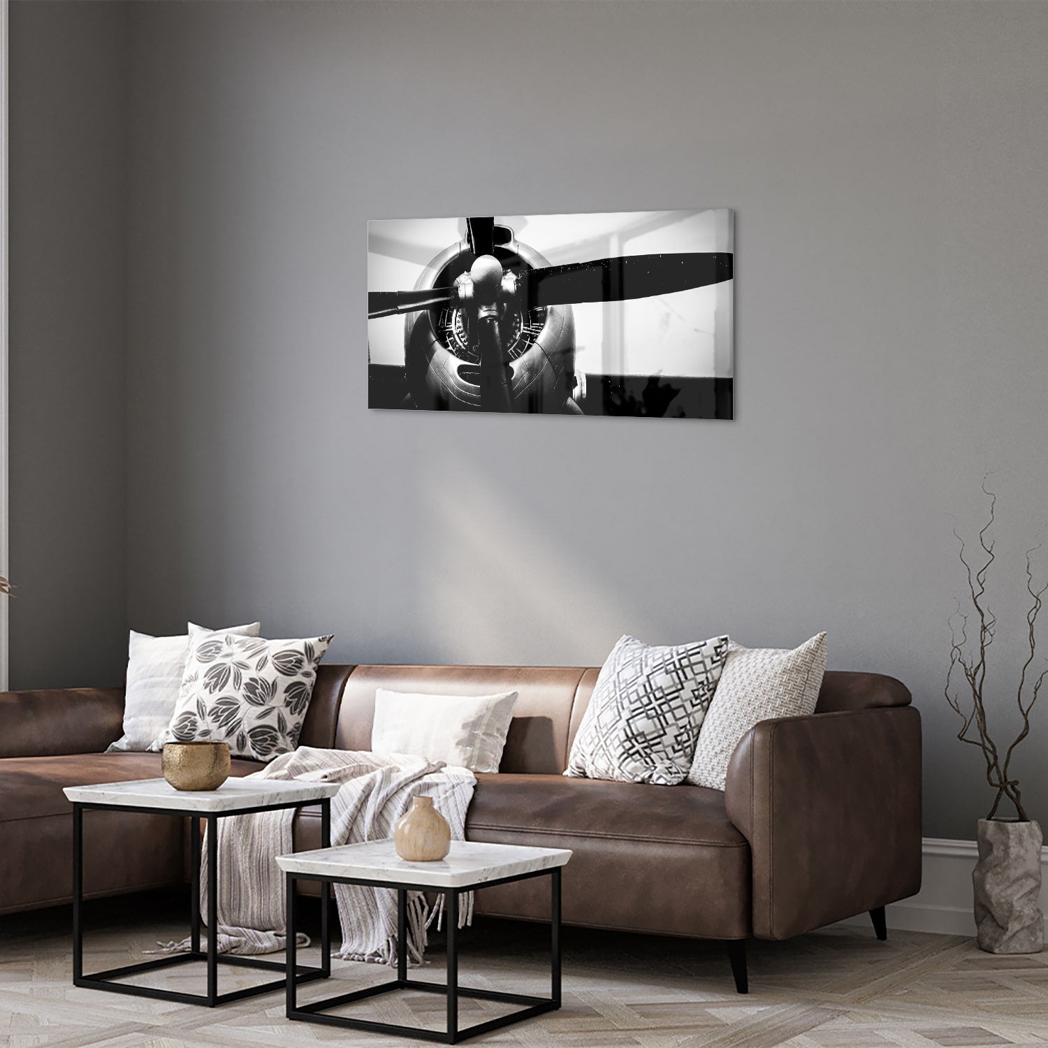 Zwart-wit glazen schilderij van een vintage vliegtuigpropeller tegen een lichte muur.