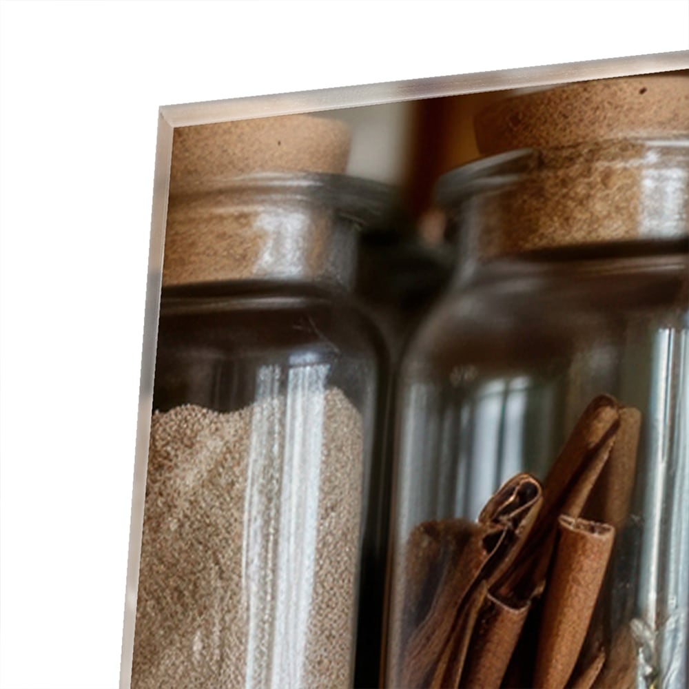 Glazen schilderij met een houten plank vol Mason jars gevuld met specerijen.