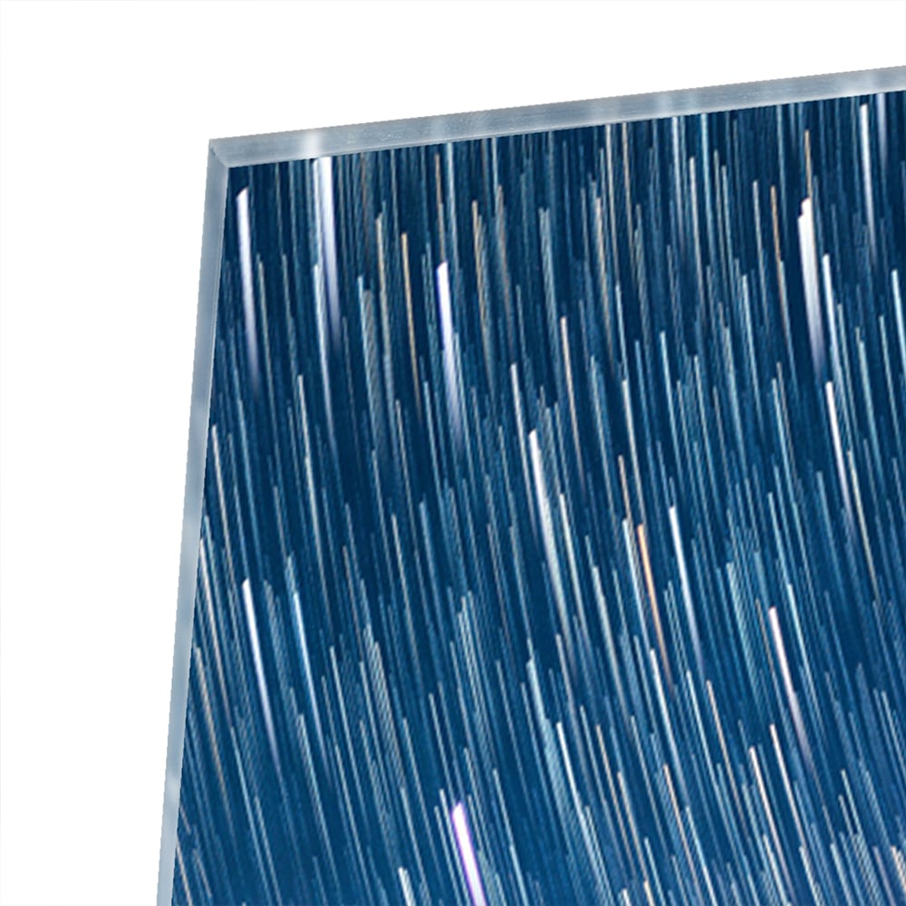 Glazen schilderij met sterrenhemel boven bergen, hangend aan de muur.