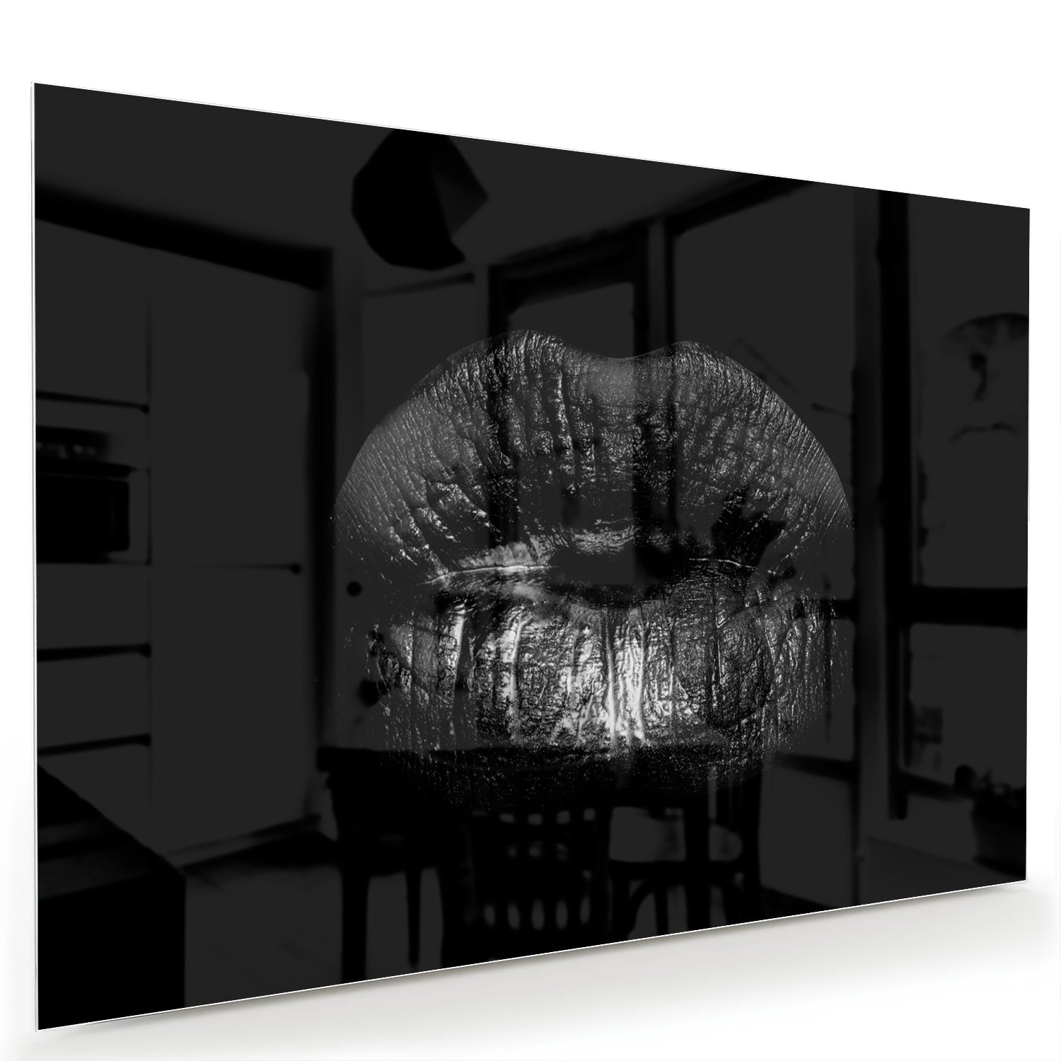 Zwart glazen schilderij met een artistieke lippenprint aan de muur.