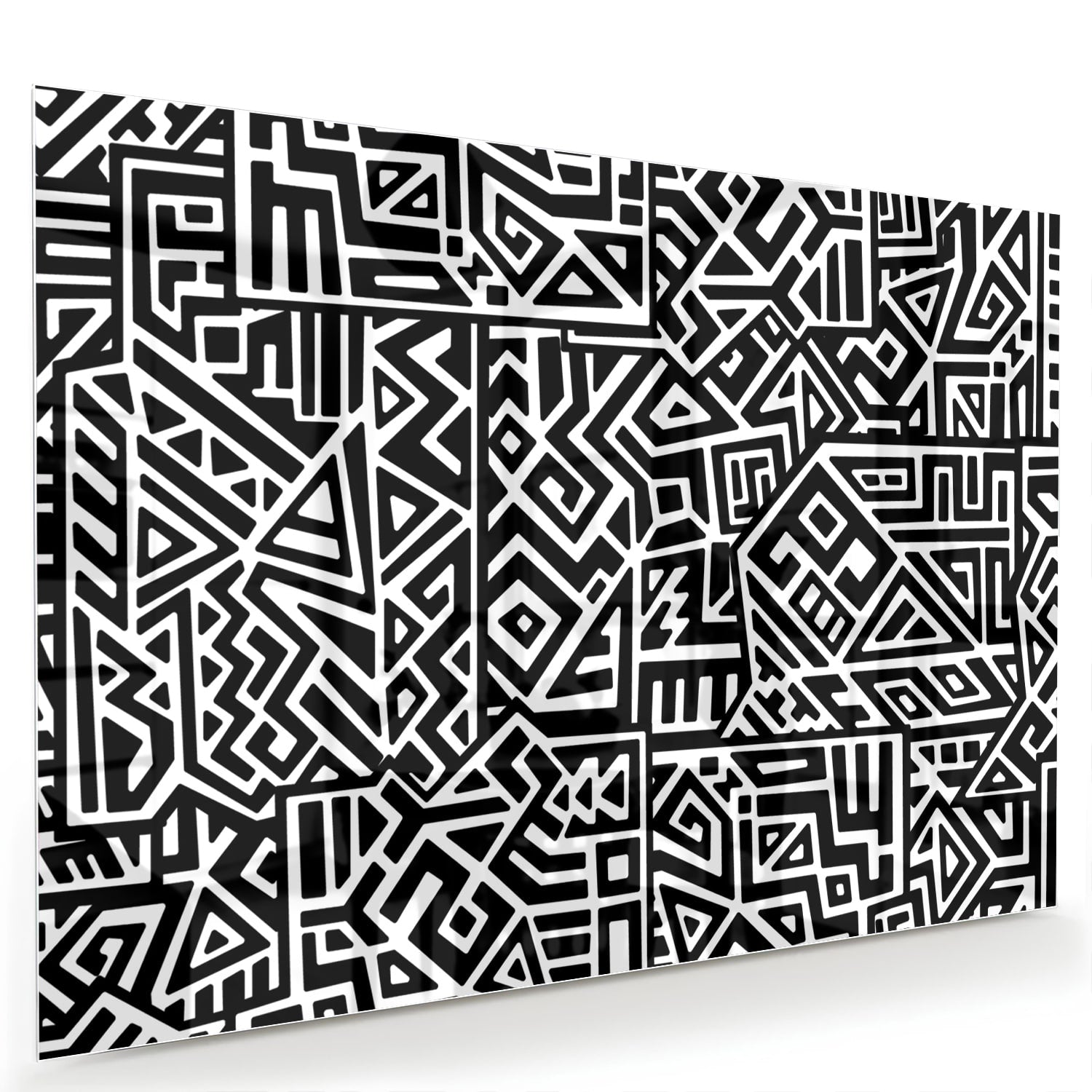 Zwart-wit glazen schilderij met abstract patroon aan de muur in een moderne woonkamer.