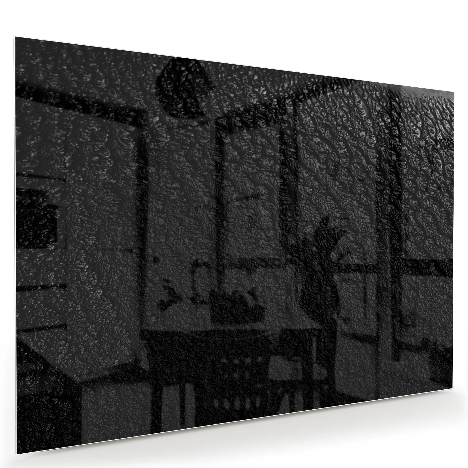 Zwart glazen schilderij aan een witte muur in een moderne woonkamer.