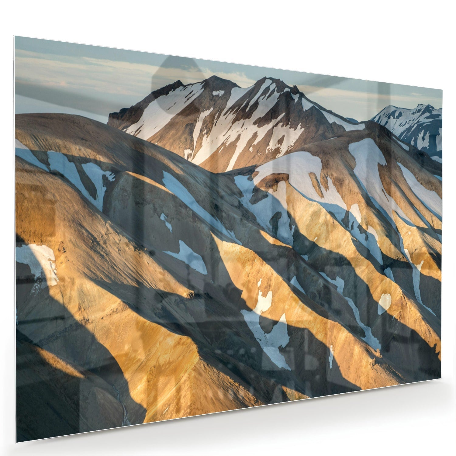 Glazen schilderij van bergen in blauw en goud, hanging in een stijlvolle kamer.