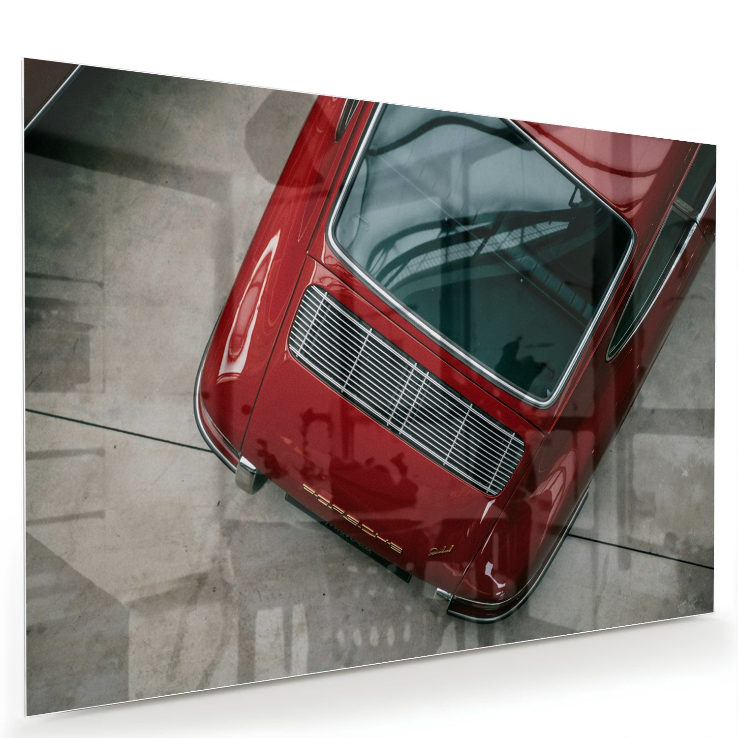 Glazen schilderij van een bovenaf gezien rode auto op een muur.