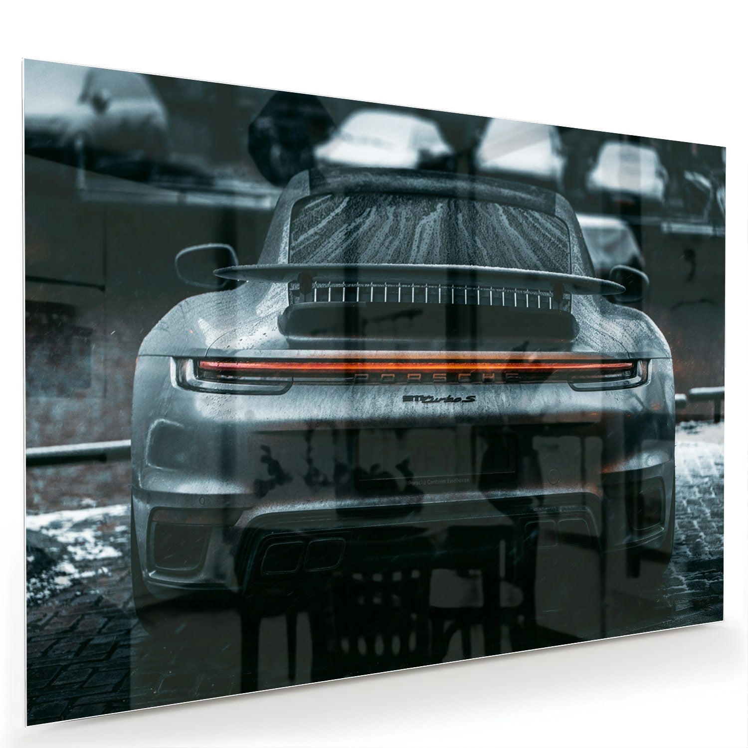 Glazen schilderij van een sportwagen aan de muur in een lichte woonkamer.