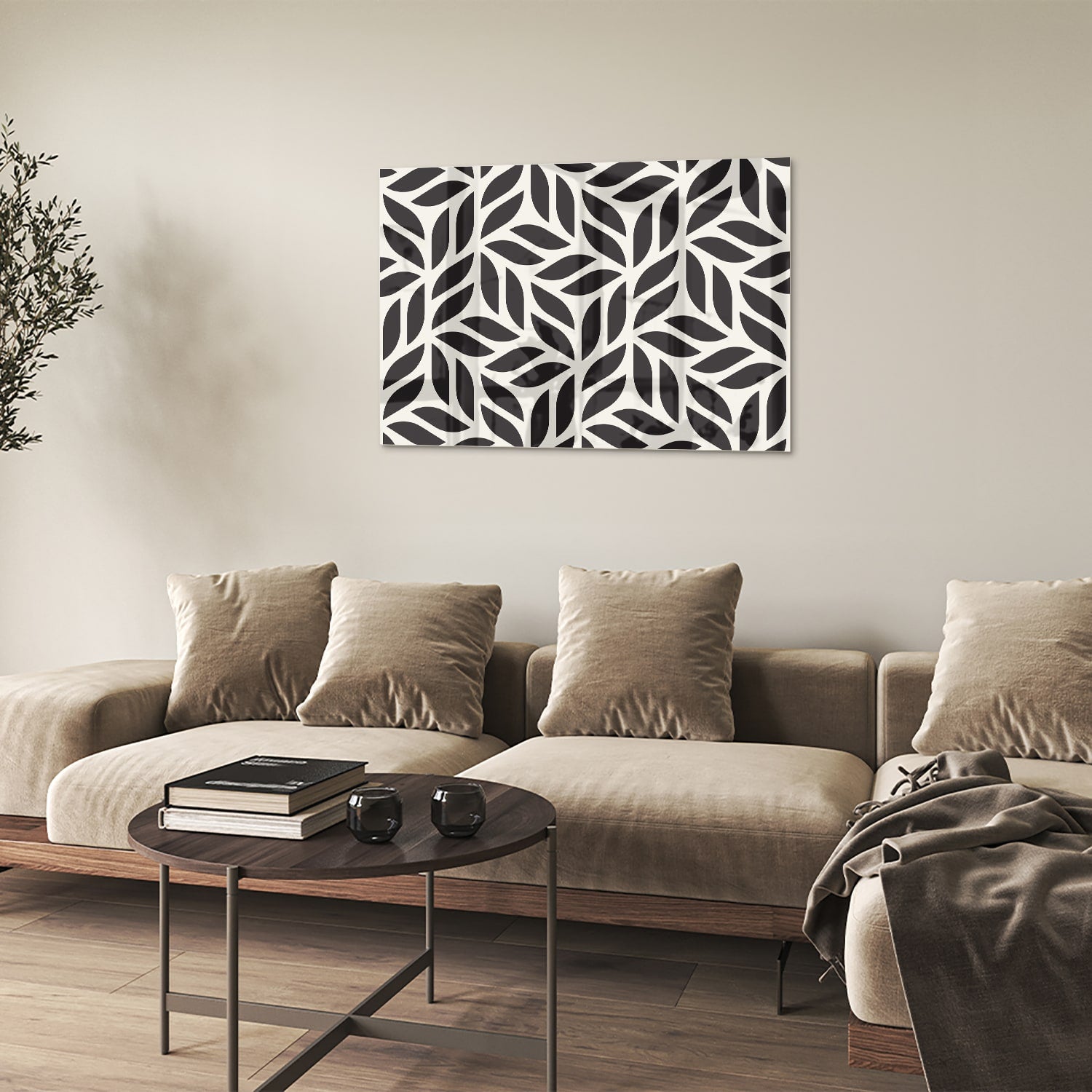 Zwart-wit glazen schilderij met bladerenpatroon aan de muur in een moderne woonkamer.