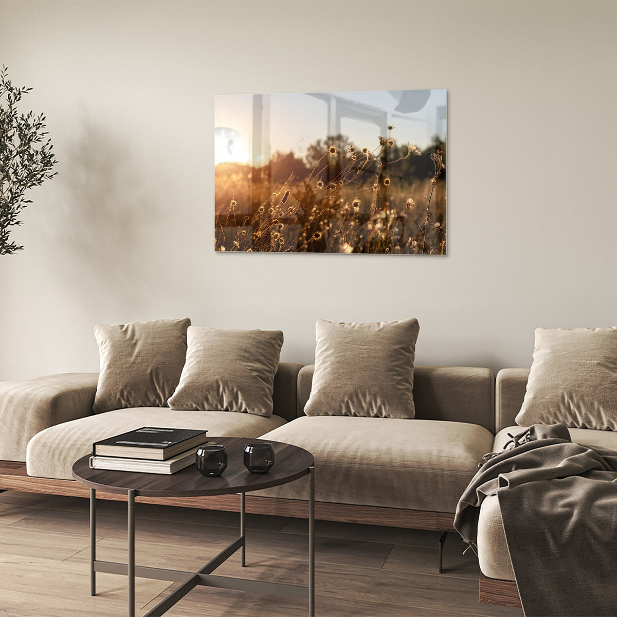 Glazen schilderij van een zonsondergang met bloeiende bloemen, hangend aan een witte muur.
