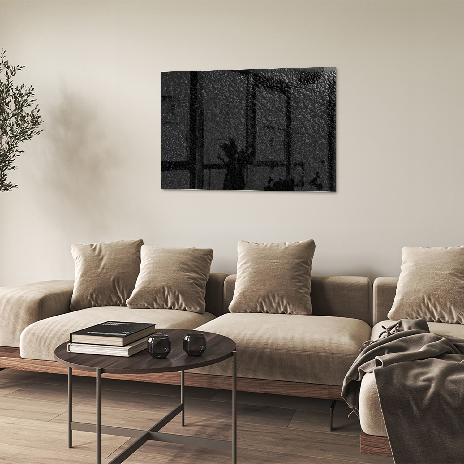 Zwart glazen schilderij aan een witte muur in een moderne woonkamer.