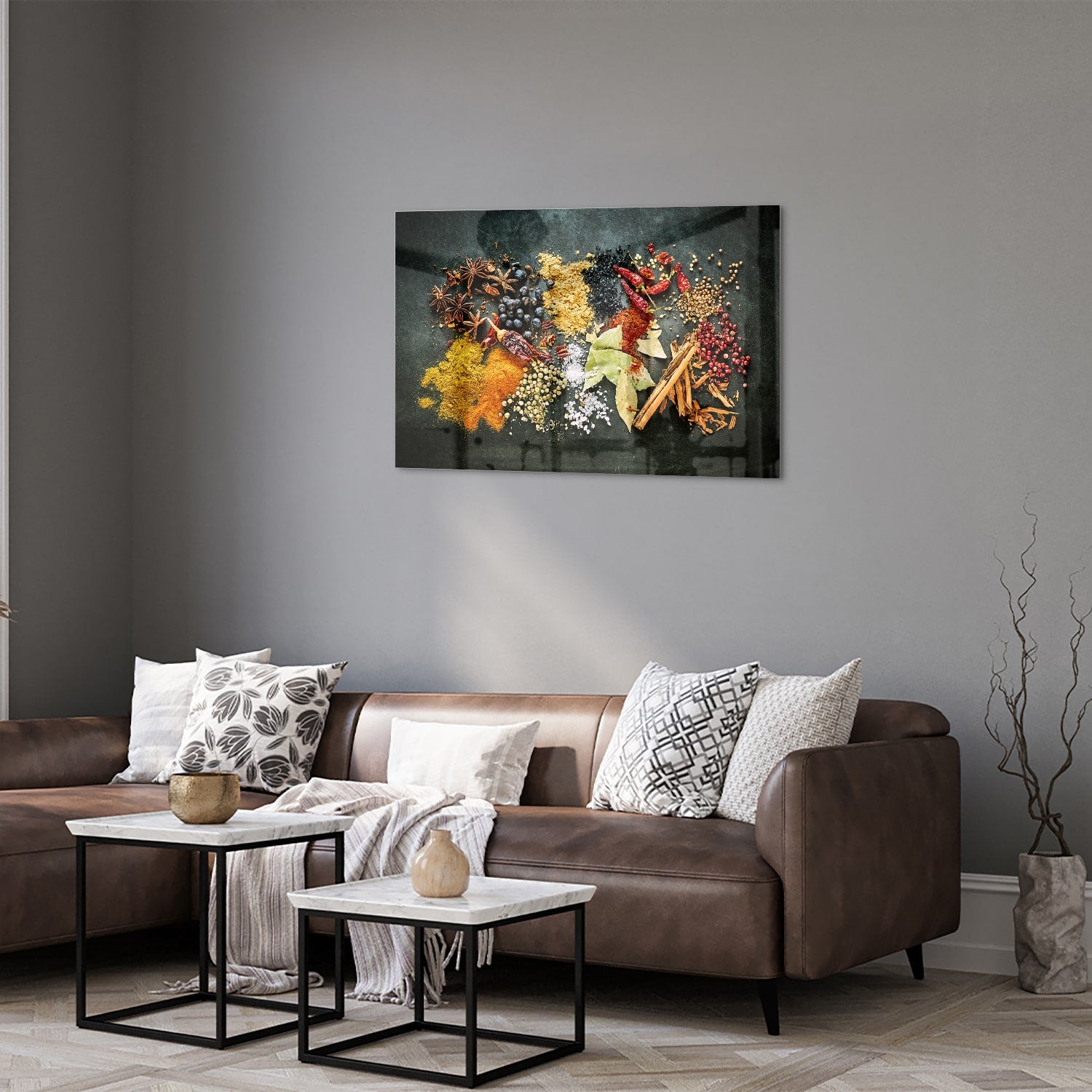 Glazen schilderij met een kleurrijke compositie van specerijen en bladeren in een moderne woonkamer.