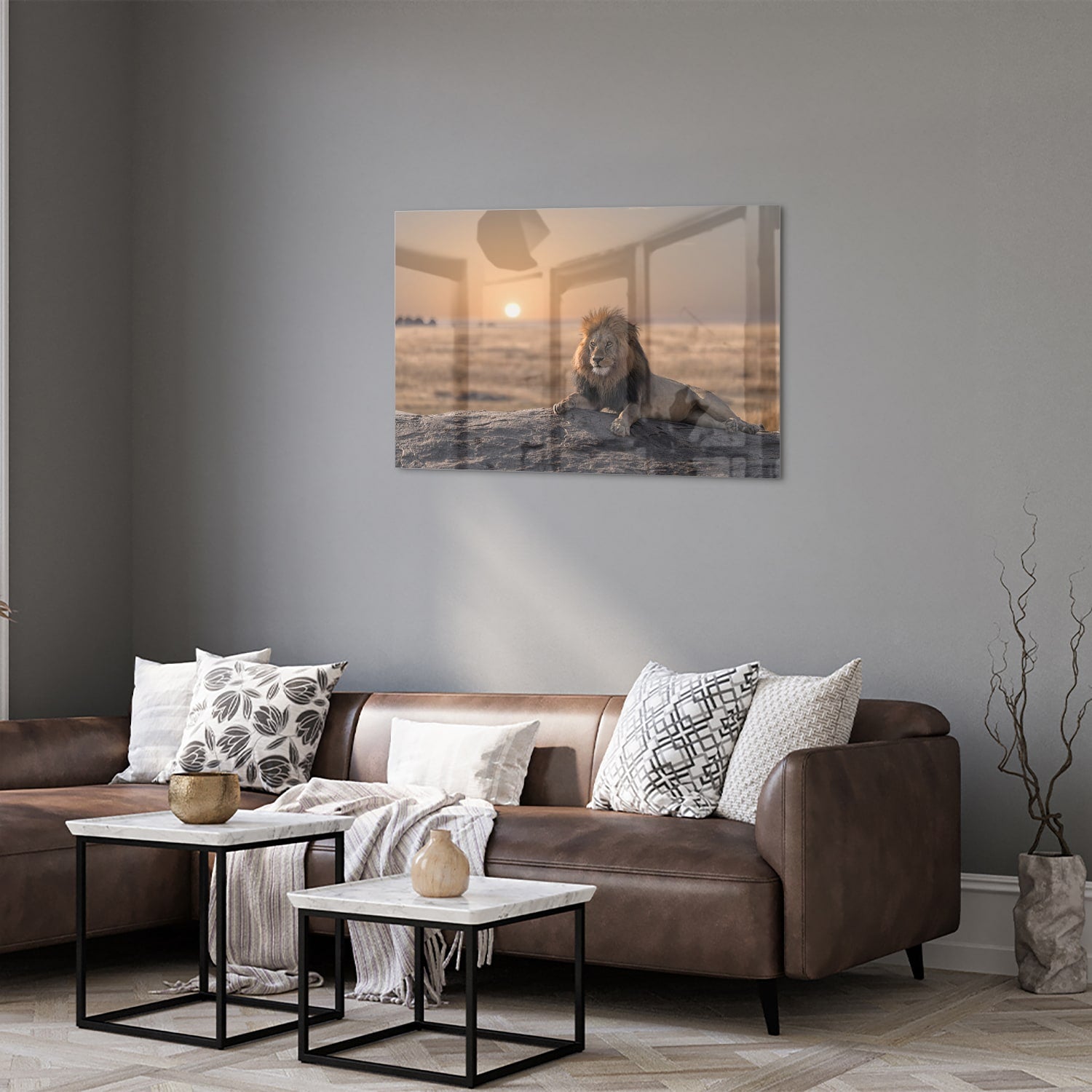 Glazen schilderij van een leeuw die op een rots ligt met zonsondergang op de achtergrond.