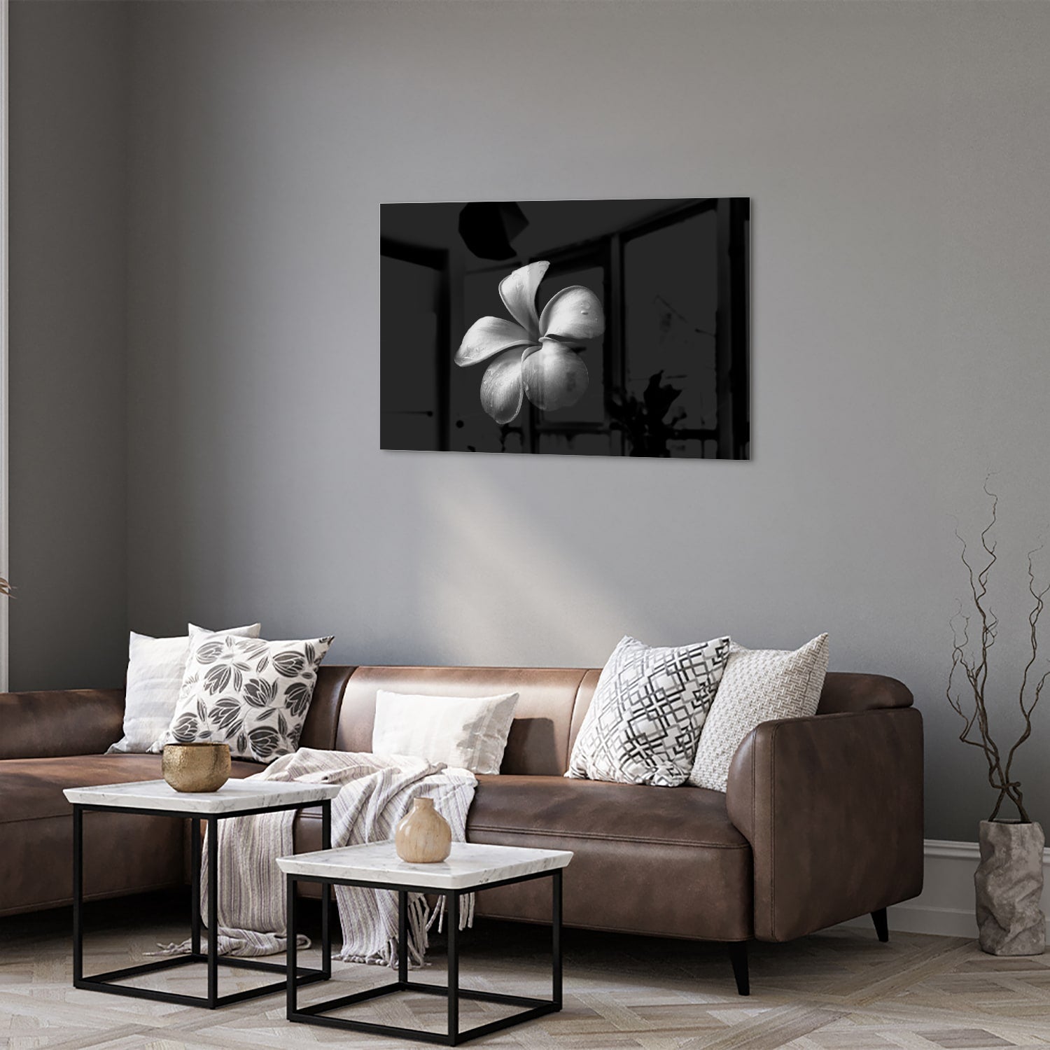 Zwart glazen schilderij met bloemmotief boven een houten kast in een lichte kamer.