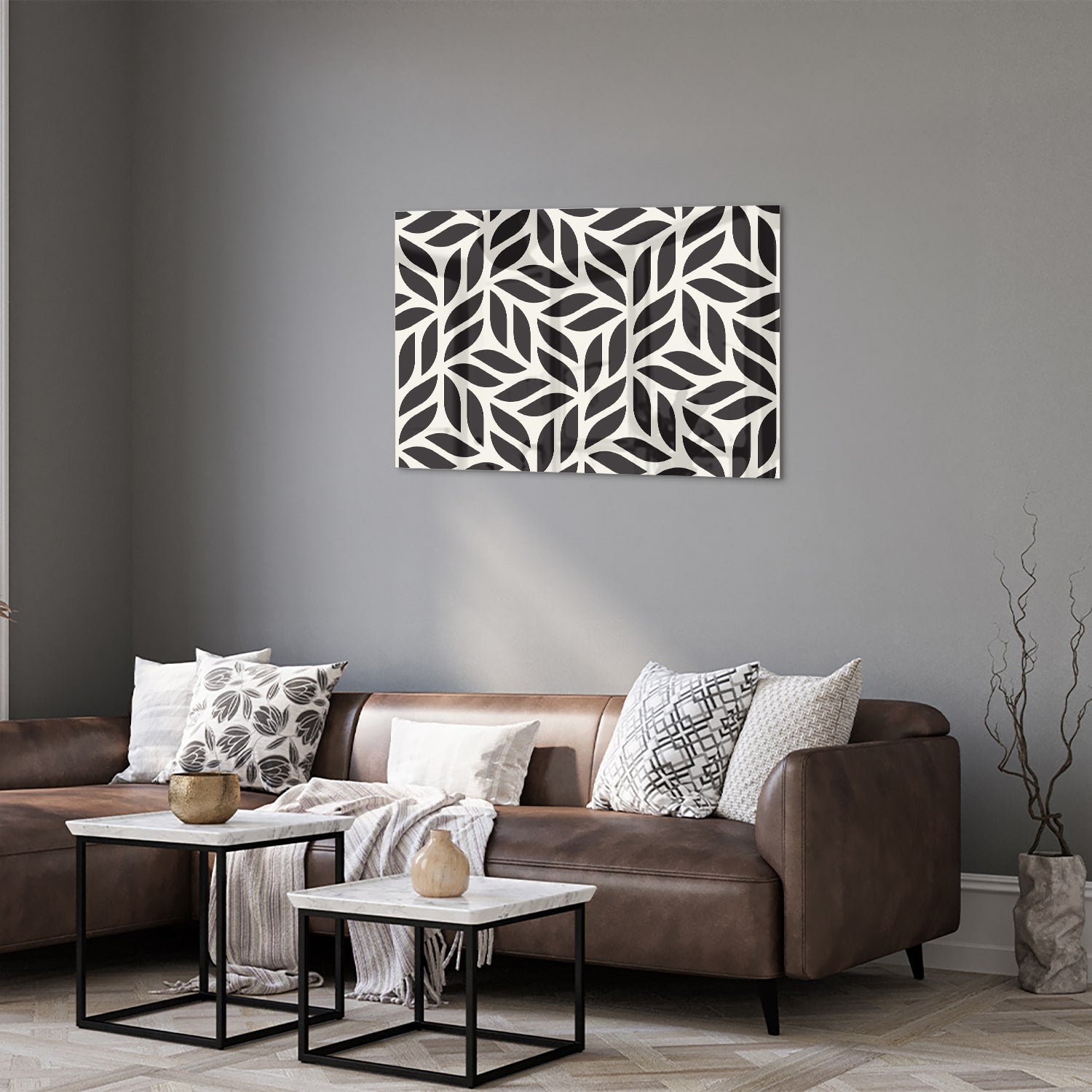 Zwart-wit glazen schilderij met bladerenpatroon aan de muur in een moderne woonkamer.