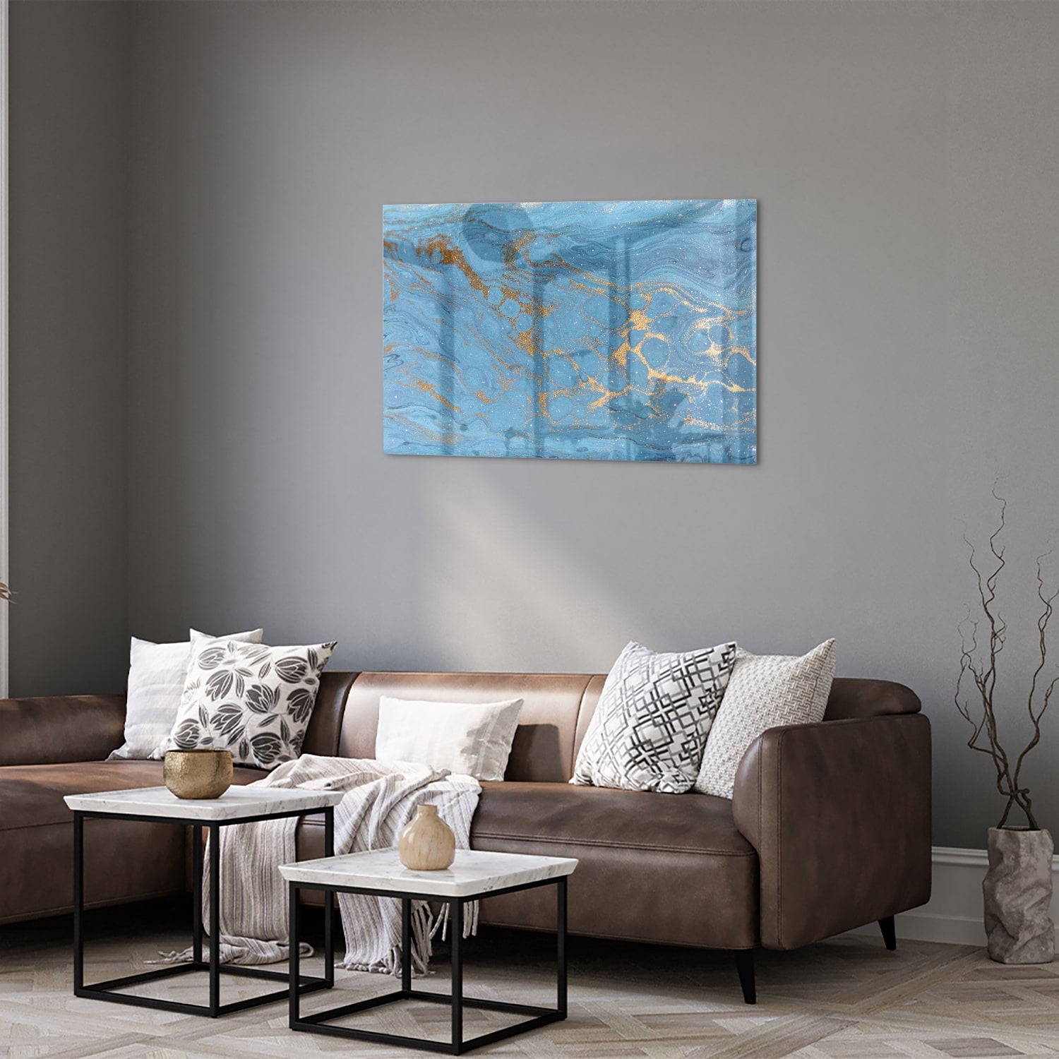 Glazen schilderij met blauw en gouden patronen aan de muur boven een houten kast.