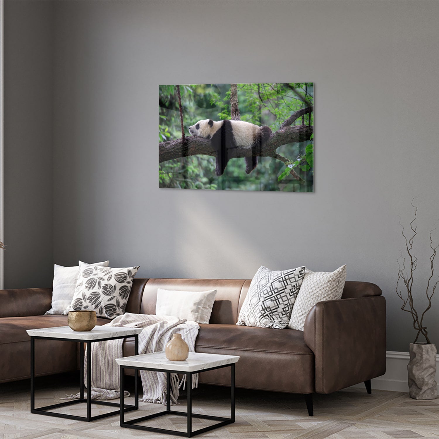 Glazen schilderij van een panda die ontspannen op een tak ligt.