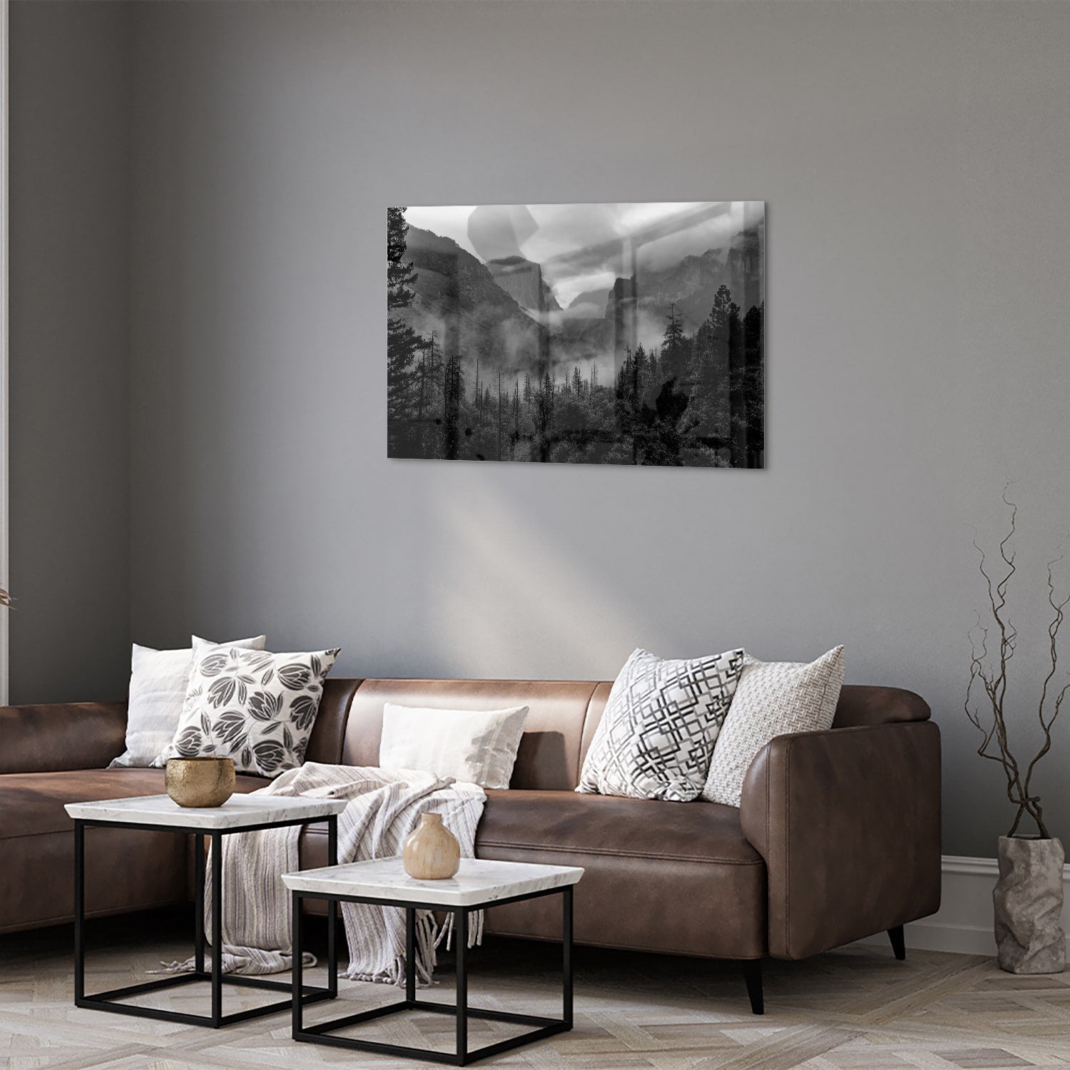 Zwart-wit glazen schilderij van een sereen berglandschap aan de muur.