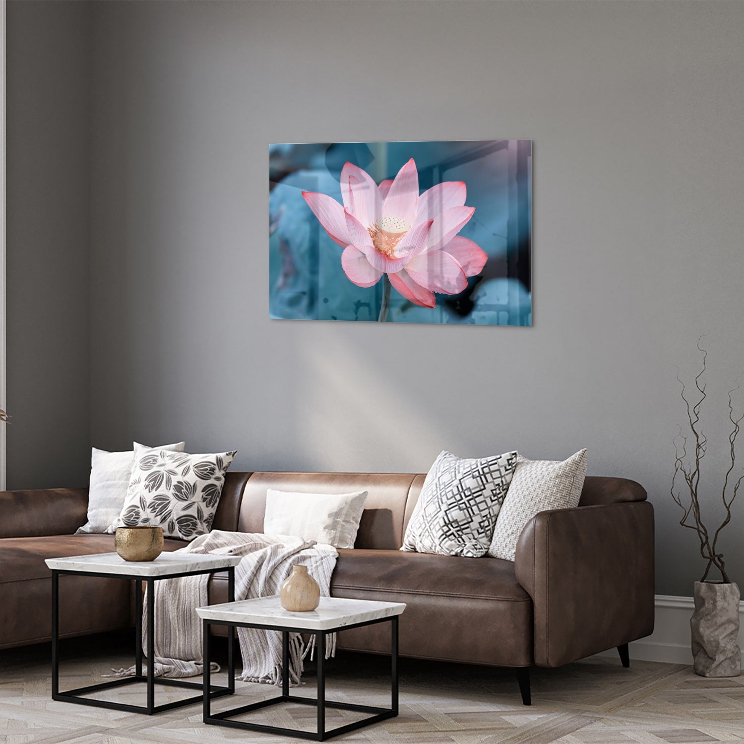 Glazen schilderij van een roze lotus boven een houten meubelstuk in een gezellige woonkamer.