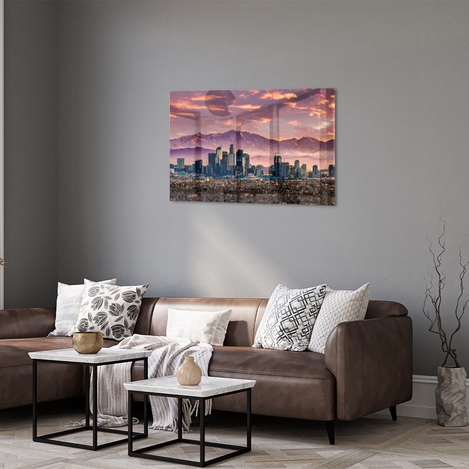 Glazen schilderij van een stadspanorama bij zonsondergang met bergen op de achtergrond.