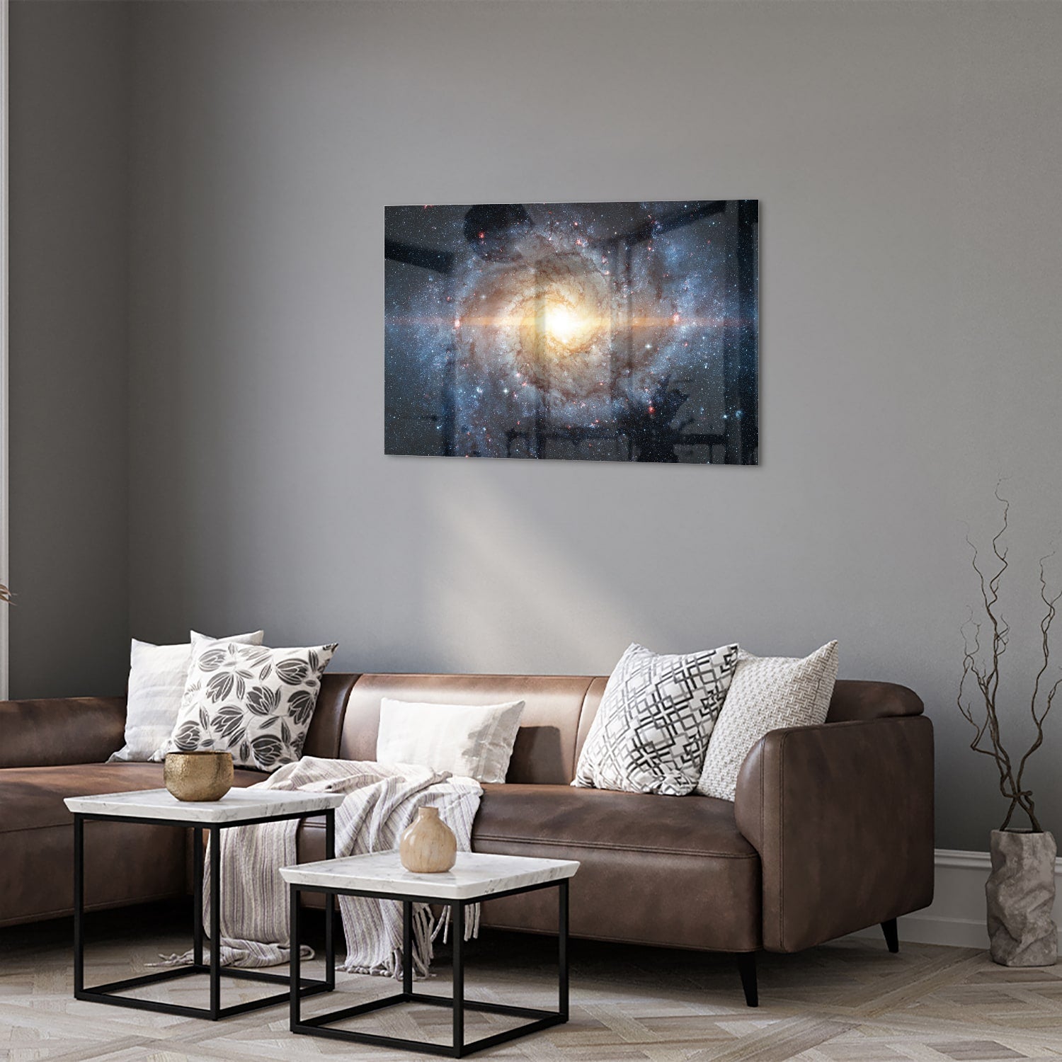 Glazen schilderij van een sterrenstelsel aan de muur in een lichte woonkamer.