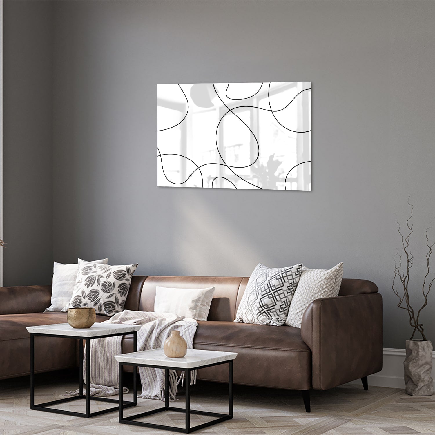 Glazen schilderij met elegante zwarte lijnen in een moderne woonkamer.