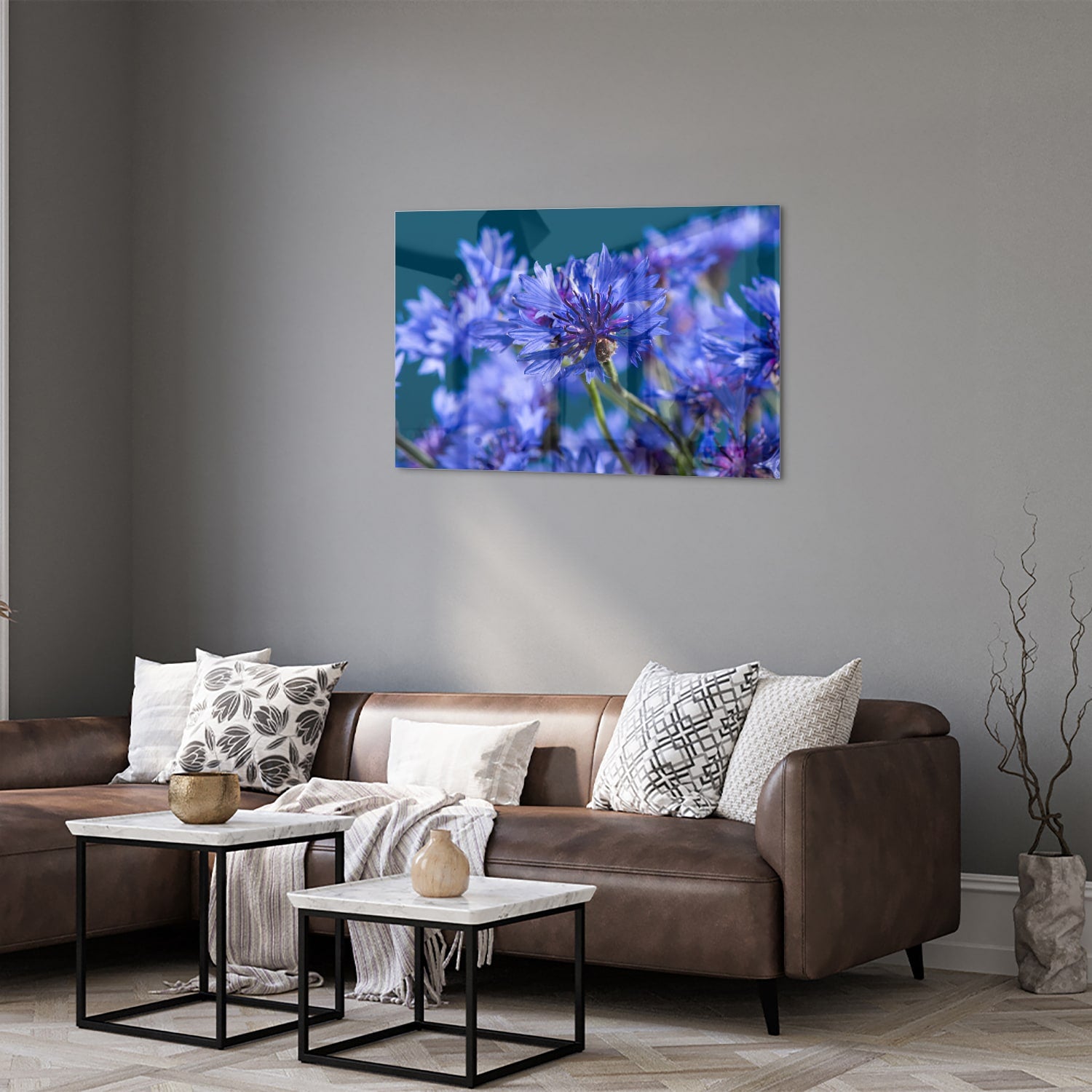 Een glazen schilderij met paarse bloemen op een witte muur, in een sfeervolle woonkamer.