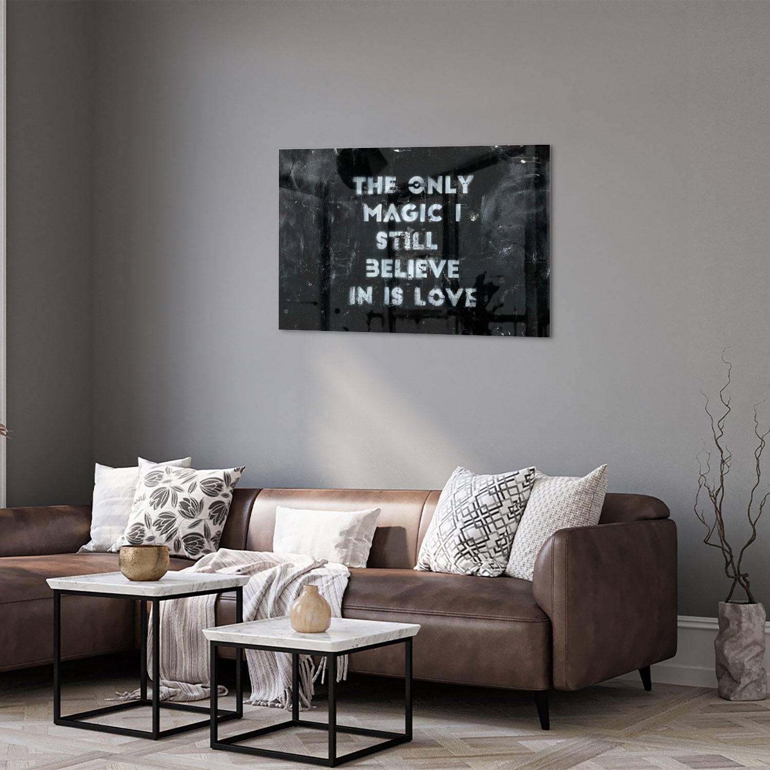 Glazen schilderij met de tekst 'The only magic I still believe in is love', hangt aan de muur in een lichte woonkamer.